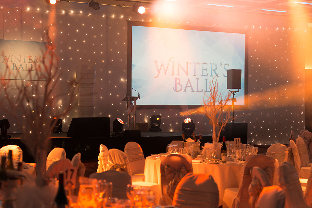 Elegant banquet hall for London Suite Christmas Party with festive lighting and stage.