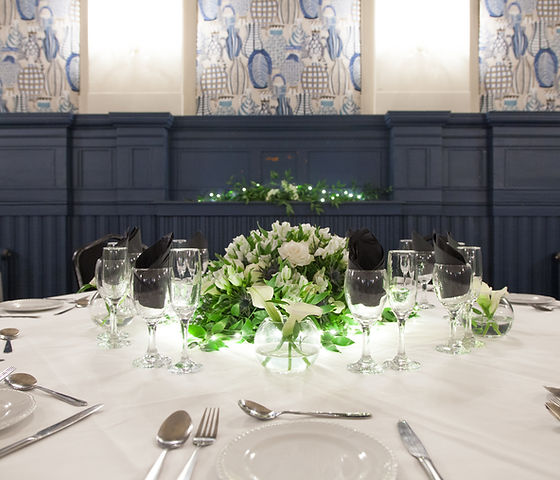 Elegant dining table with white floral centerpiece for weddings and corporate events.