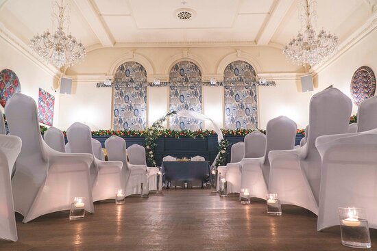 Elegant sports bar event space with white chair covers, perfect for weddings and gatherings.