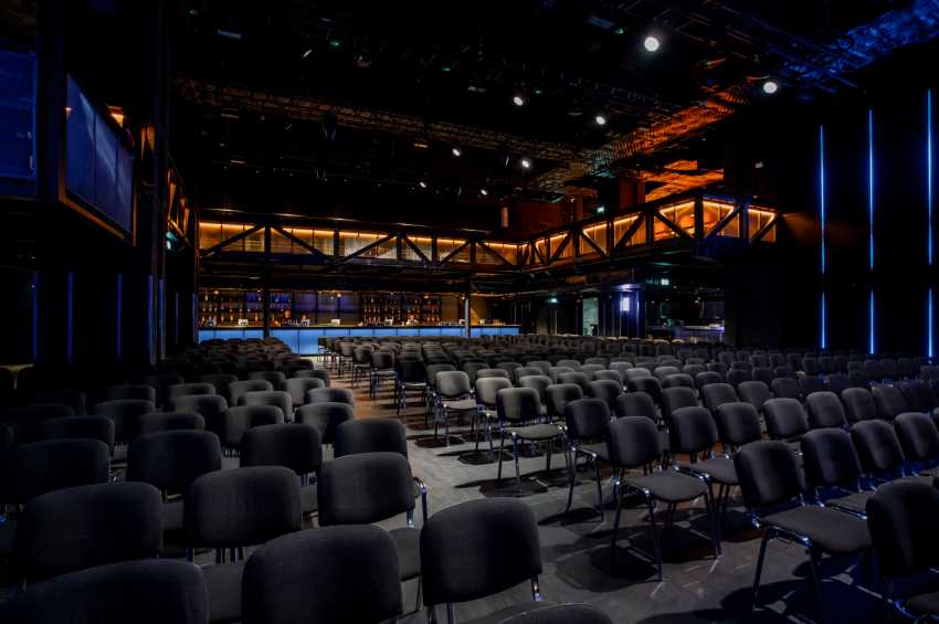 Versatile event space in London with sleek chairs for conferences and presentations.