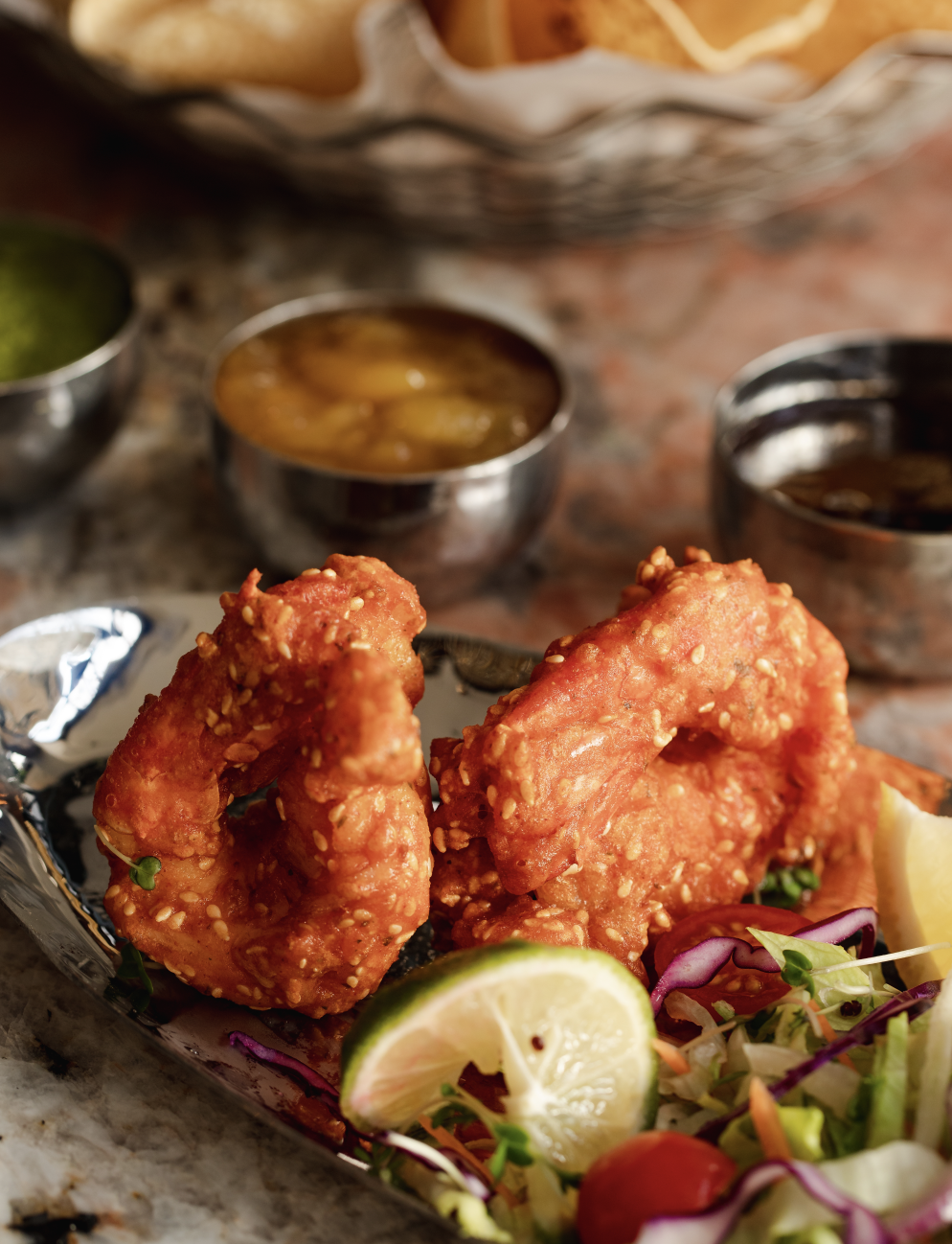 Private dining dish with crispy sesame snacks and vibrant sauces for events.