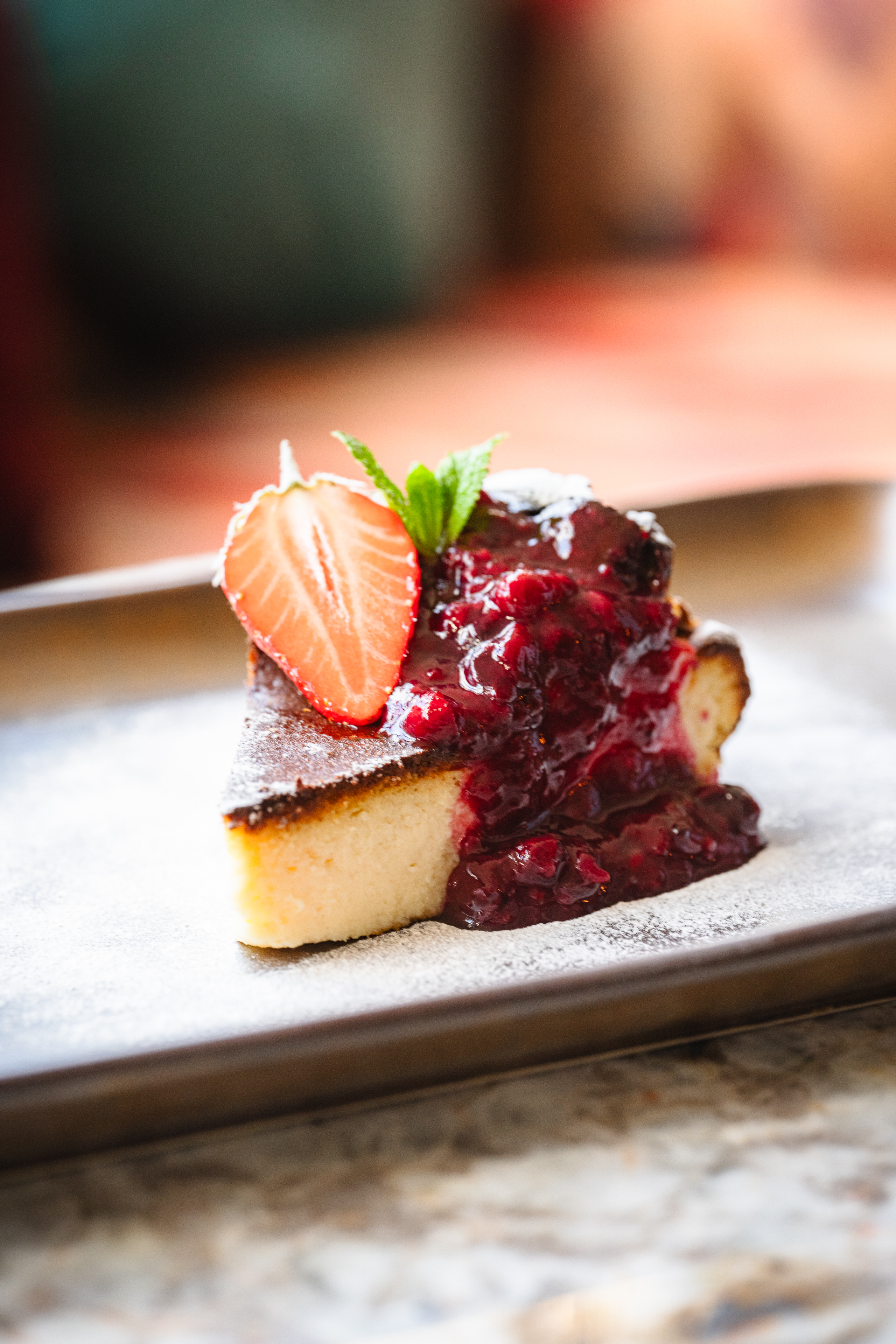 Private dining dessert with cake, berry compote, and fresh strawberry for events.