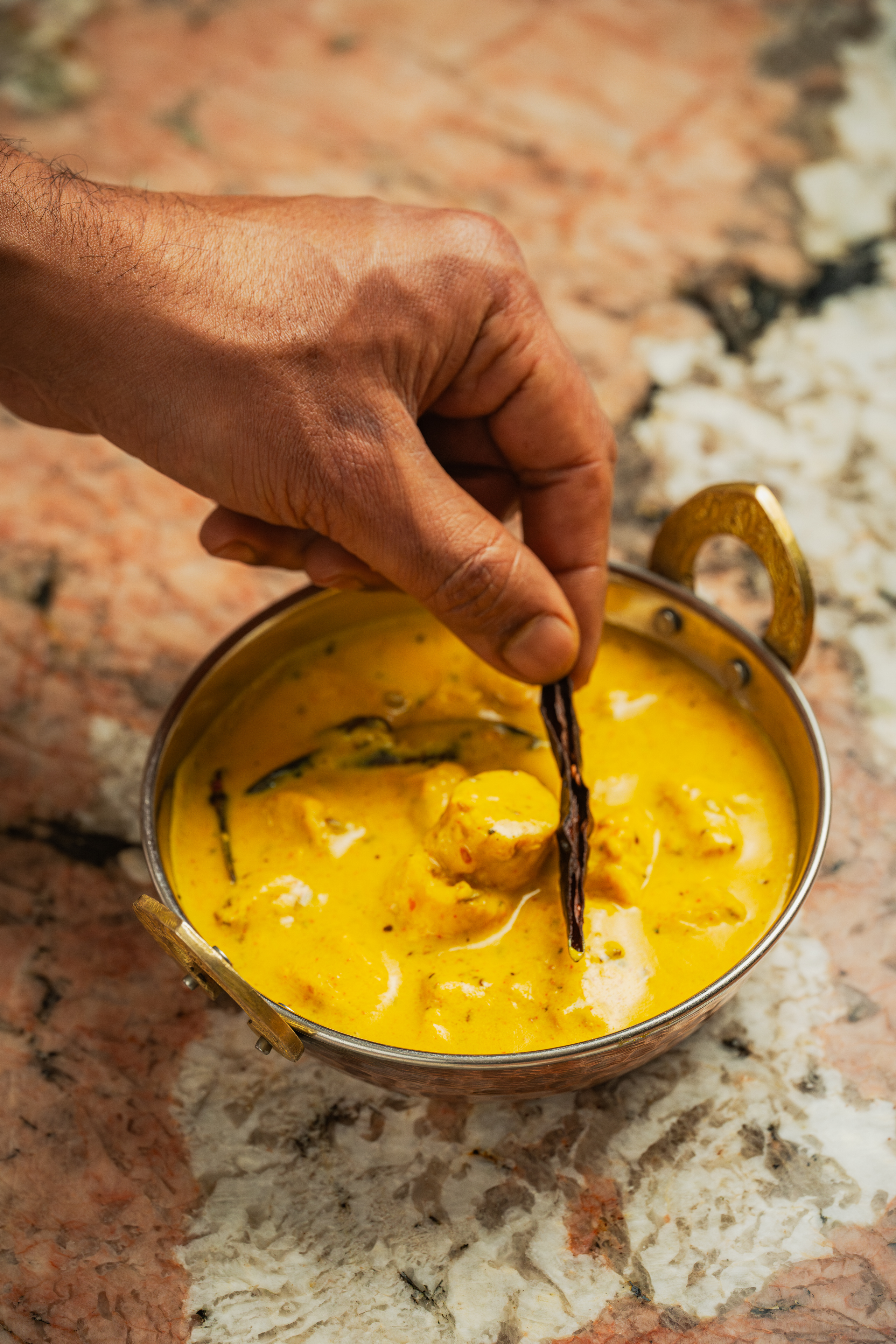 Private dining at Bombay Delight: hand dipping food in creamy curry for memorable events.