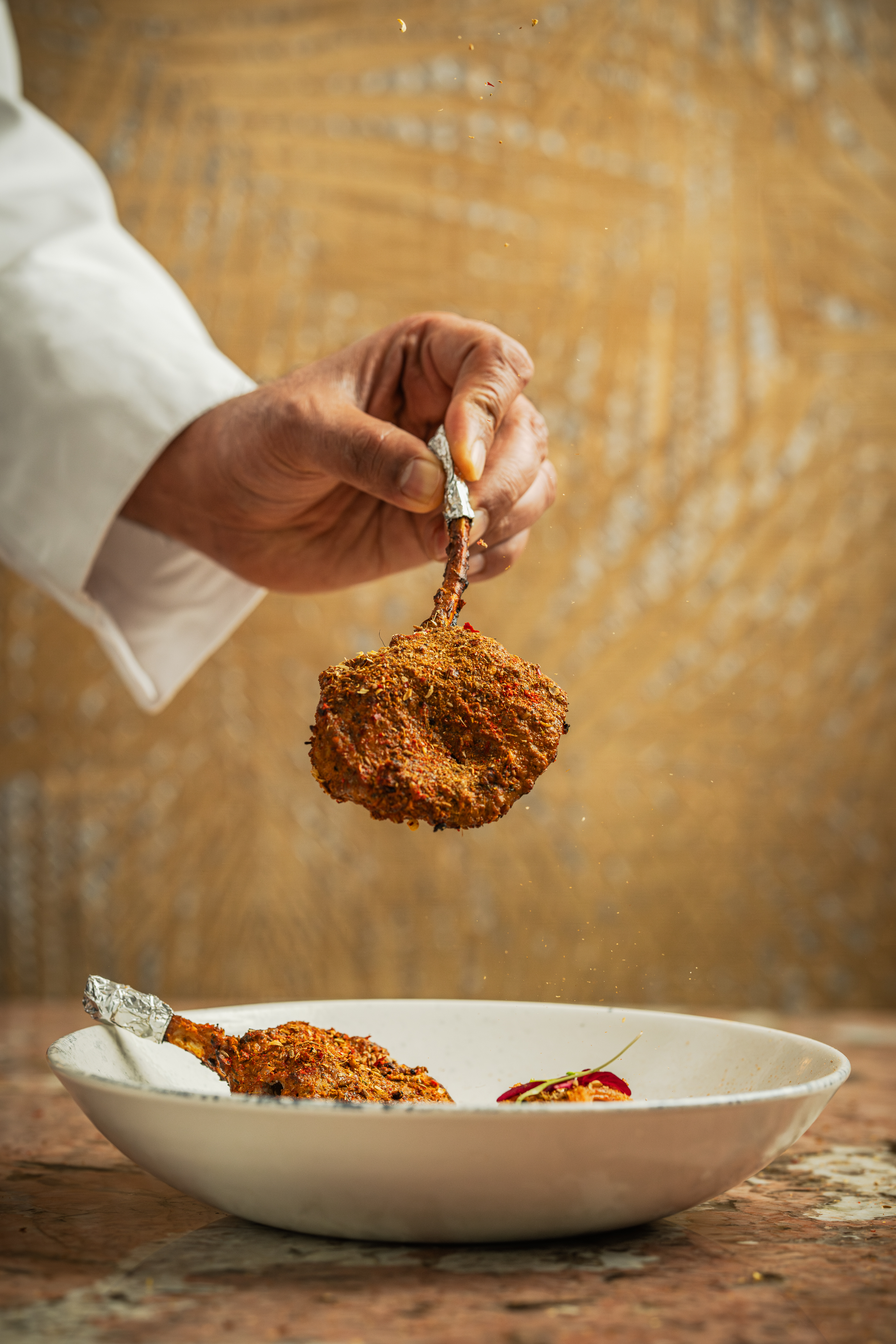 Hand holding vibrant spice blend for private dining event at Bombay Delight.