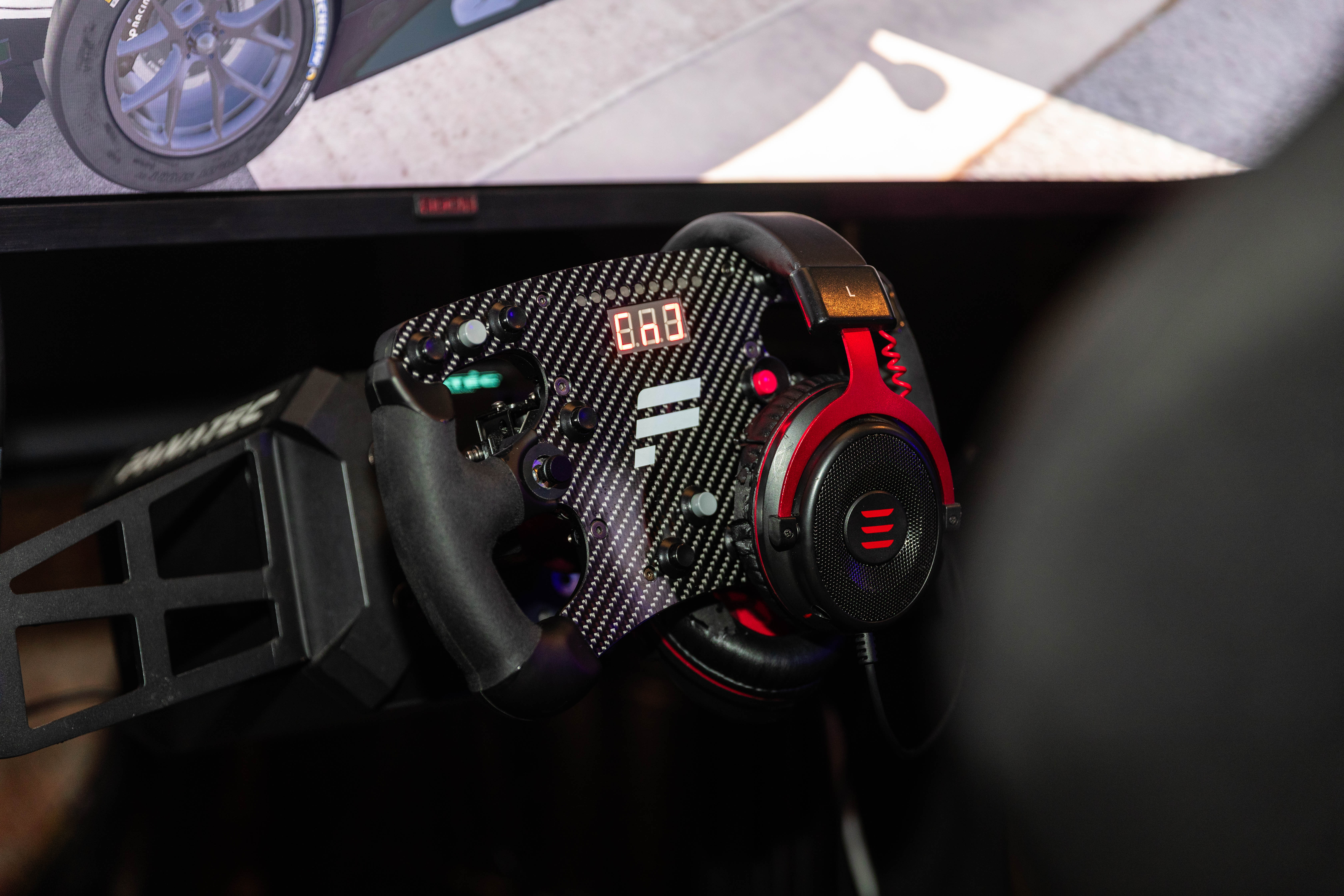 High-tech racing simulator with steering wheel for corporate team-building events.