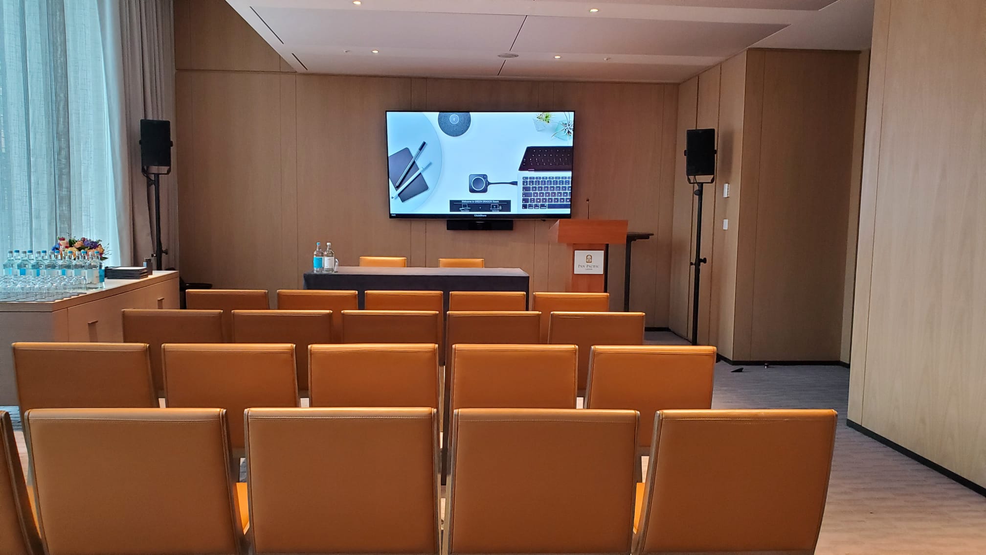 Meeting room setup at Pan Pacific London with large screen for presentations.