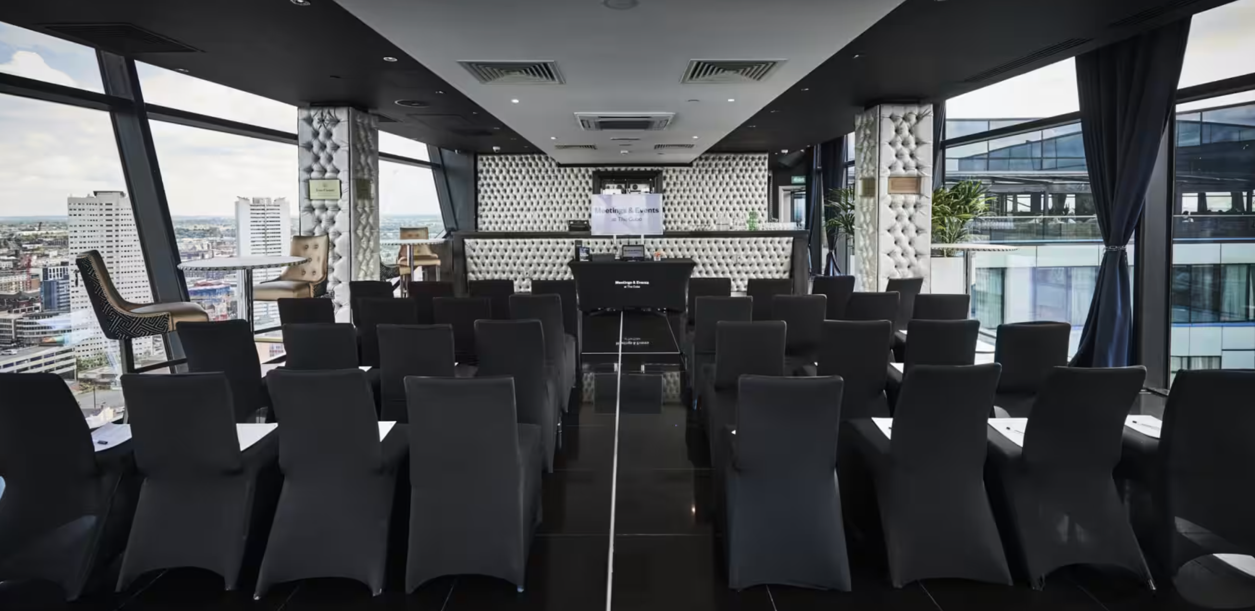 The Champagne Room at The Cube Hotel, modern event space with black chairs and natural light.
