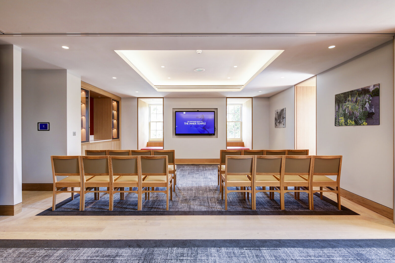 Modern meeting space with large screen, ideal for presentations and workshops.