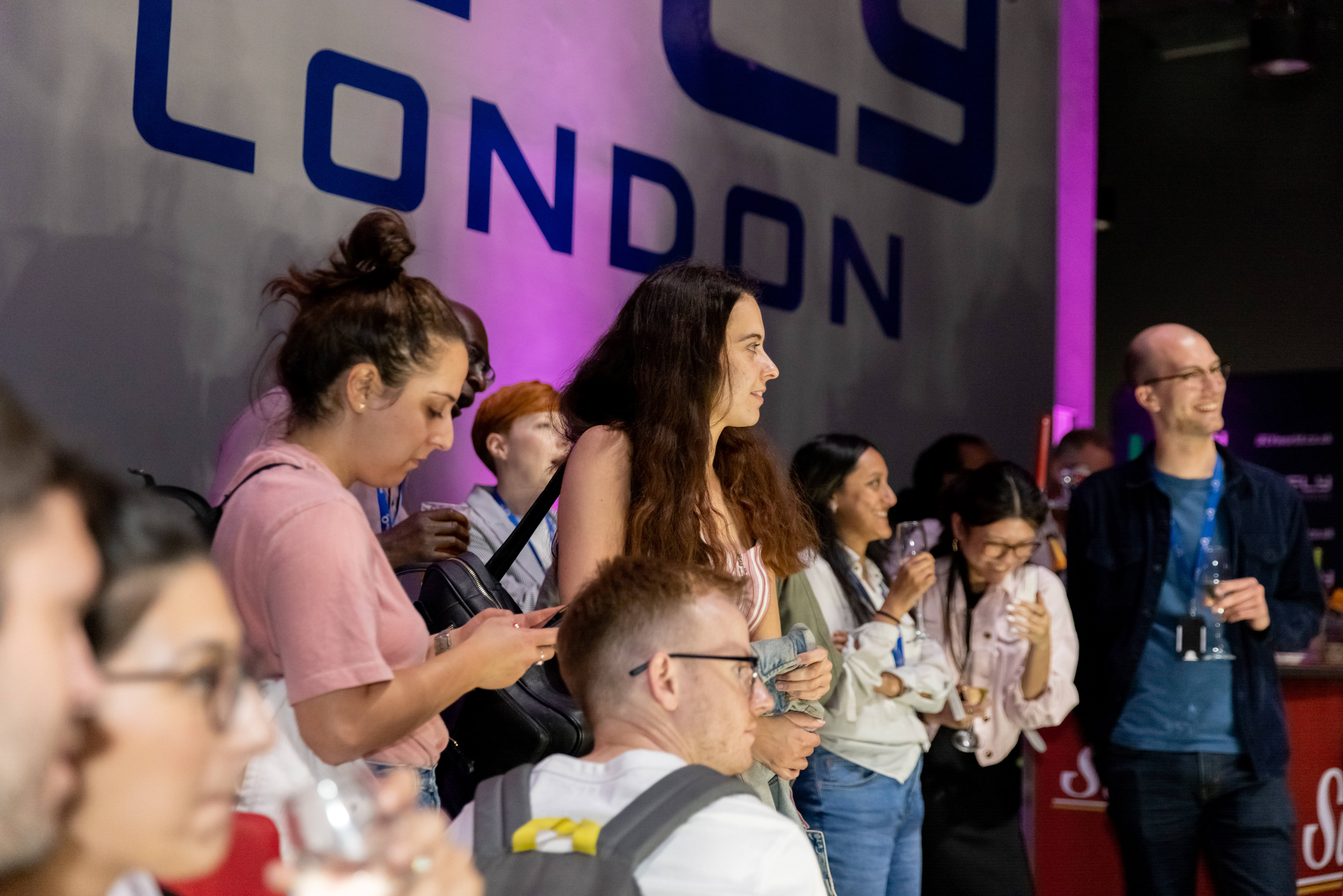 Diverse group networking at iFLY Indoor Skydiving, modern venue, relaxed atmosphere.