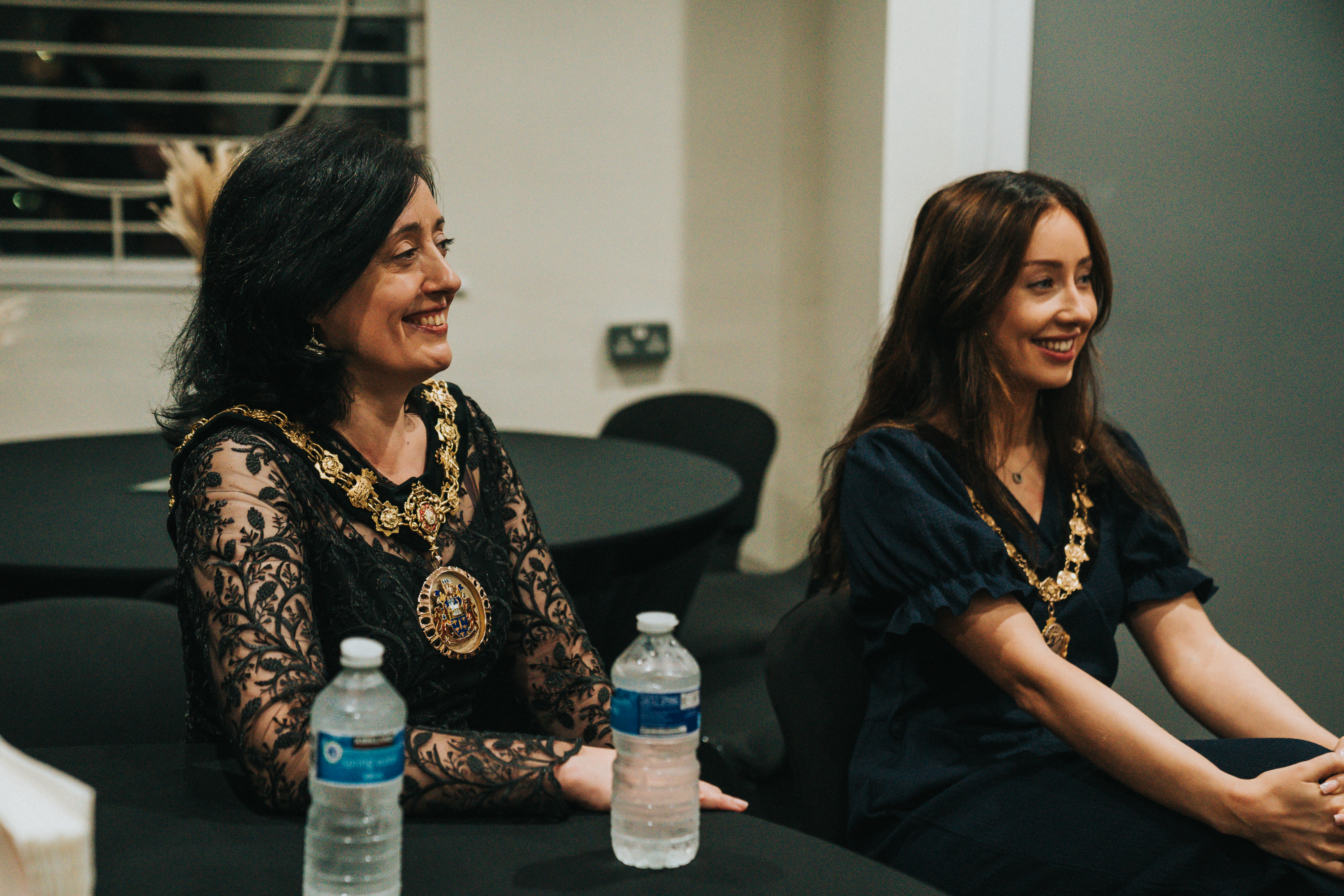Elegant women networking at Victory Outreach Manchester's Large Function Hall event.