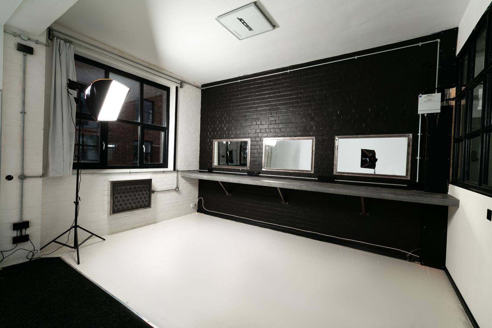 Versatile event space with black brick wall, ideal for gatherings and creative sessions.