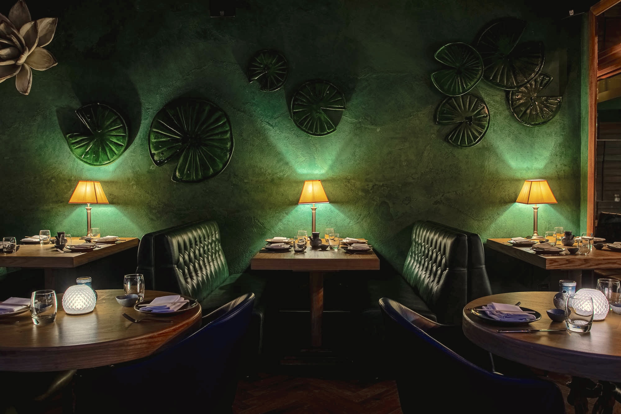 Intimate dining space with green backdrop for exclusive restaurant hire events.