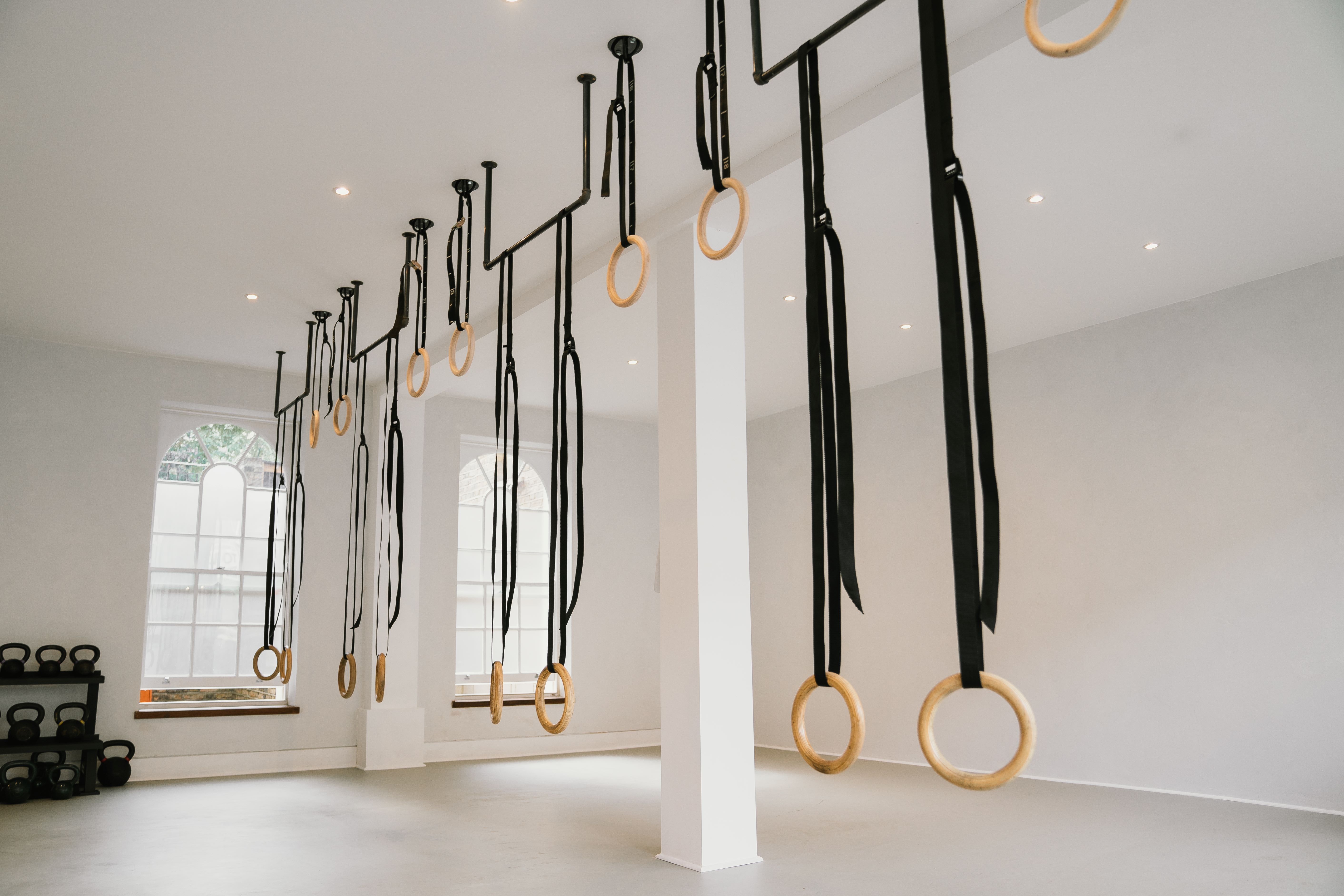 Modern fitness studio with gymnastic rings, perfect for group workouts and wellness events.