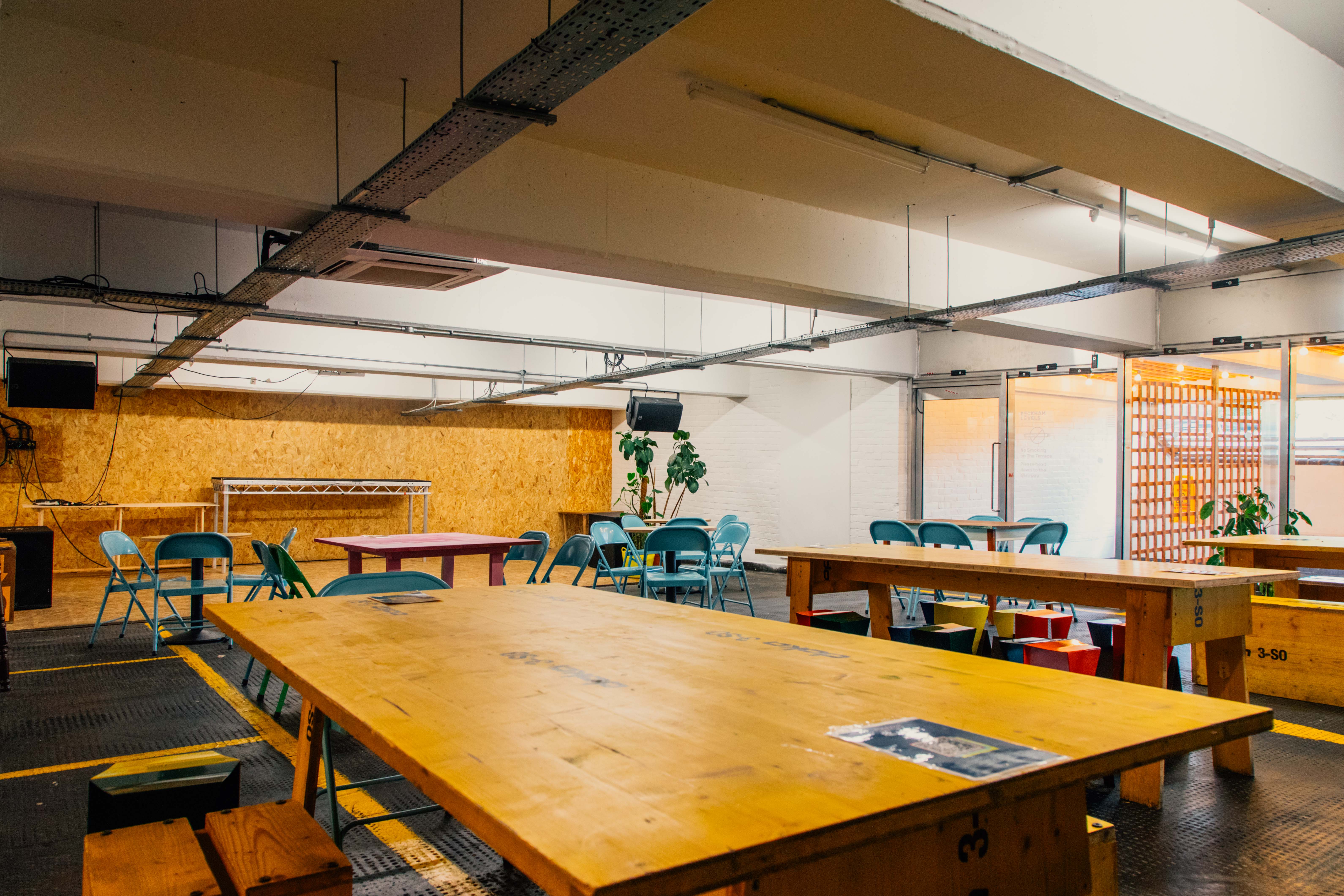 Versatile event space in Peckham Levels with communal tables for workshops and meetings.