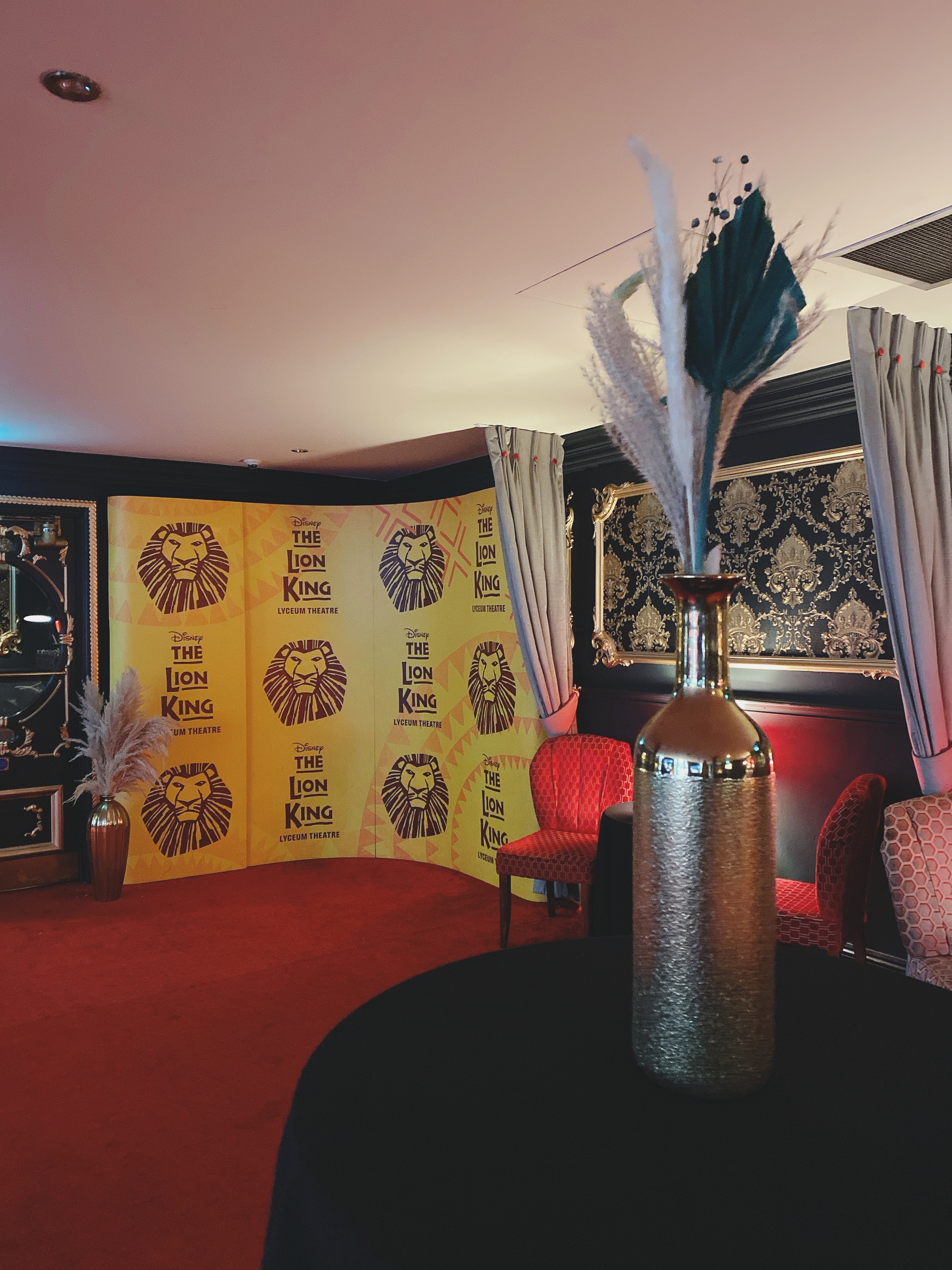 Ambassadors Lounge with Lion King backdrop, elegant decor for events and networking.
