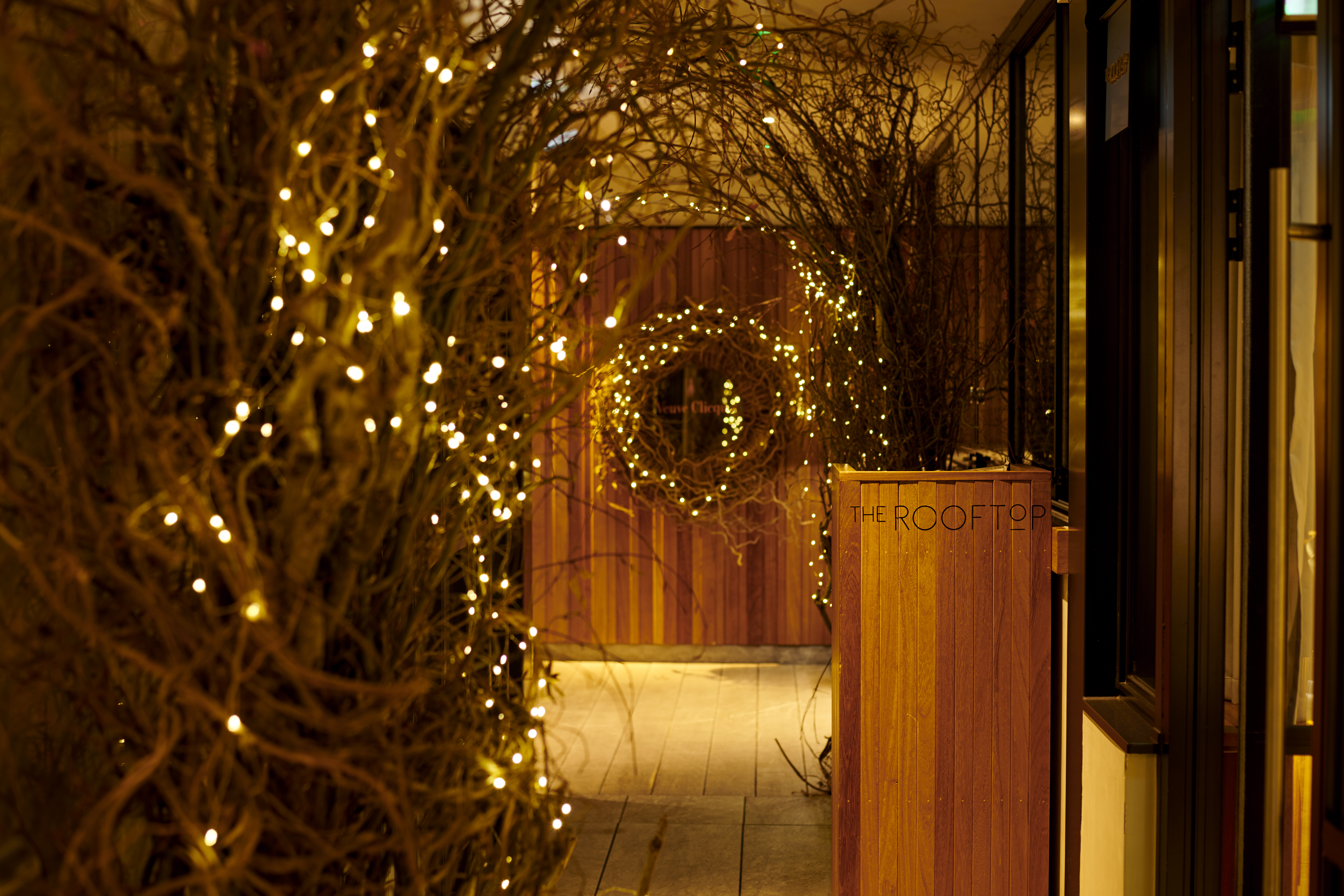 "Festive entrance at Trafalgar St James Rooftop for Christmas parties, cozy and inviting."