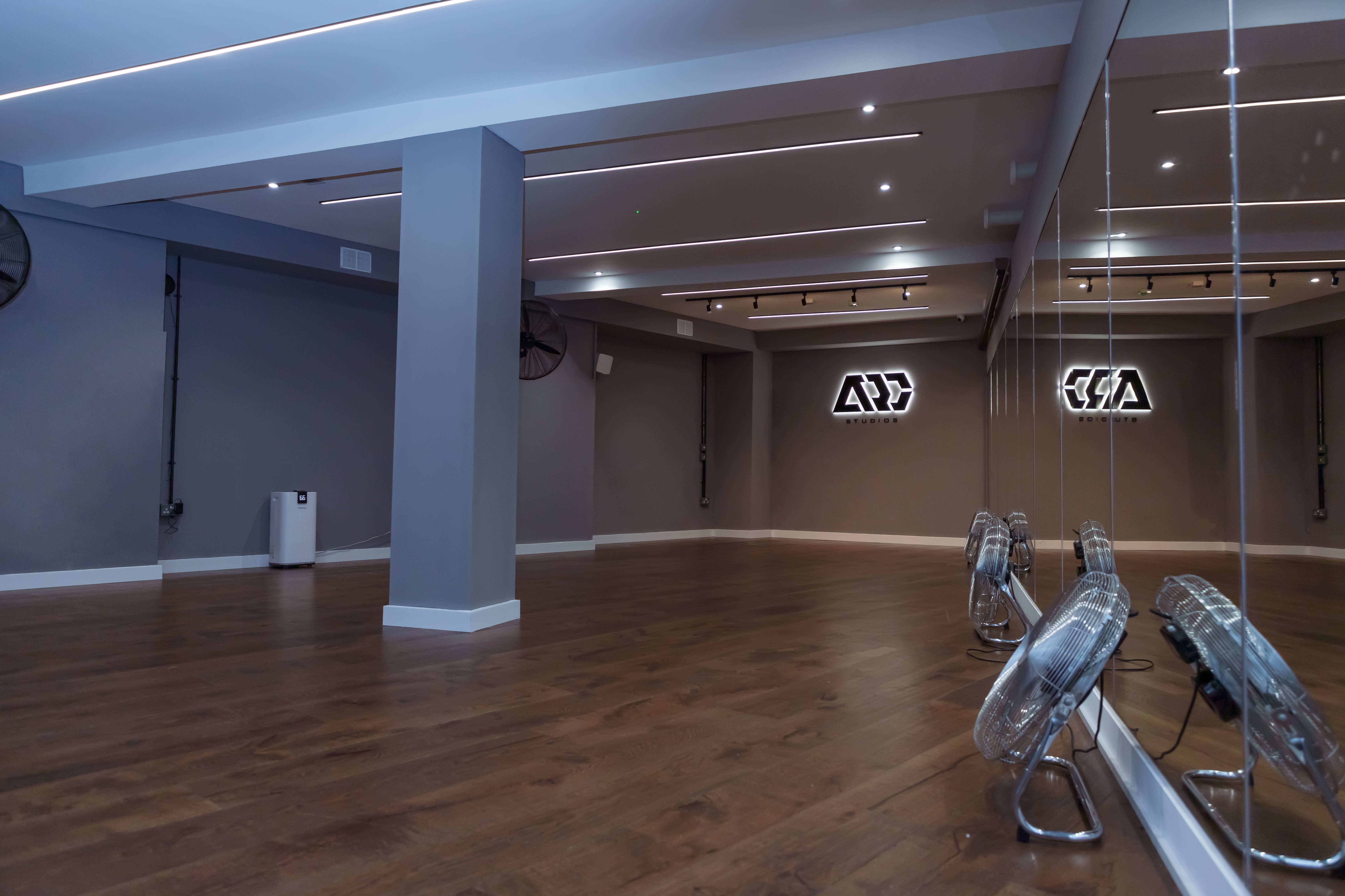 Modern event space with polished wooden floor, ideal for workshops and fitness classes.