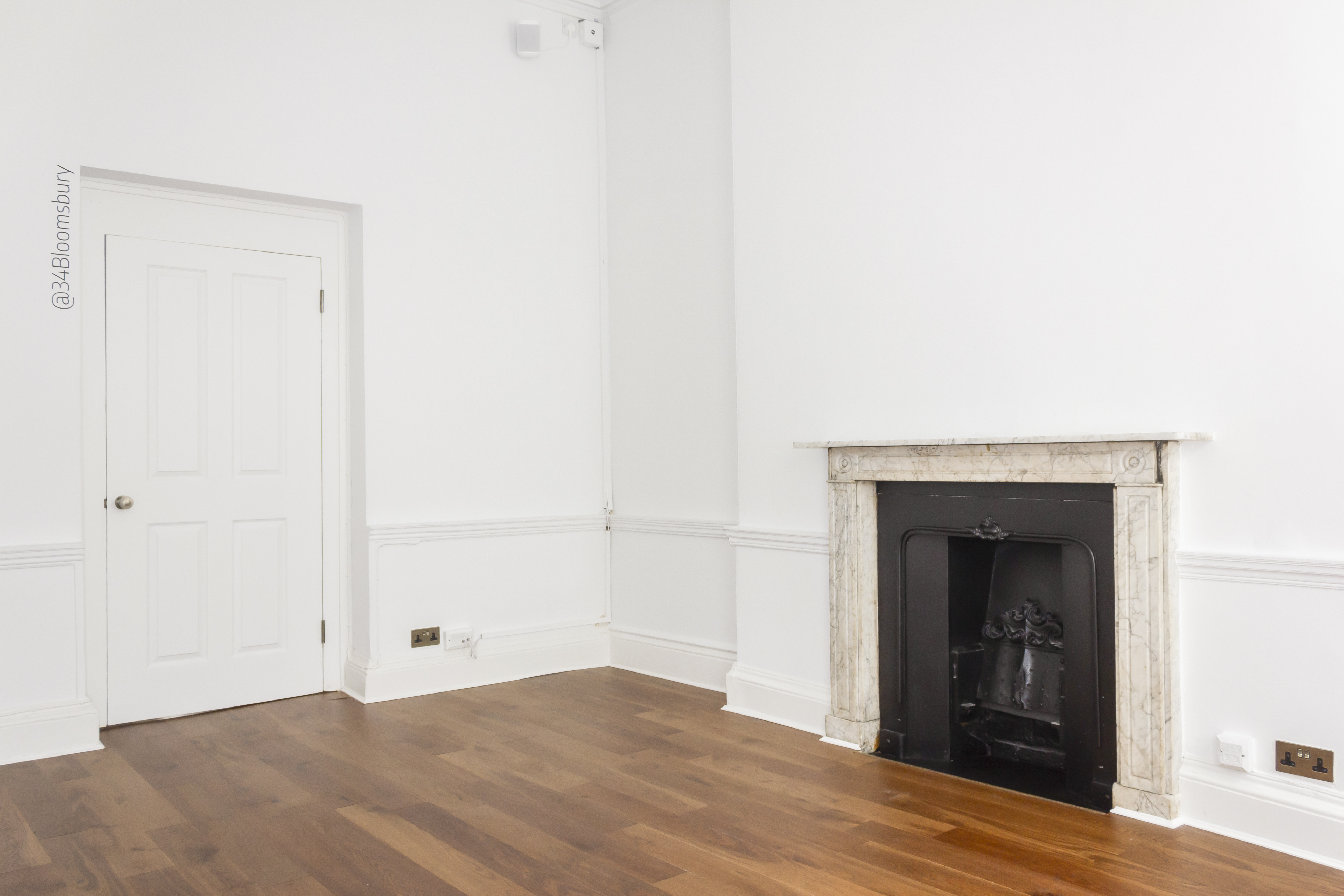 Minimalist meeting space in The Otto Room with elegant wood flooring, ideal for events.
