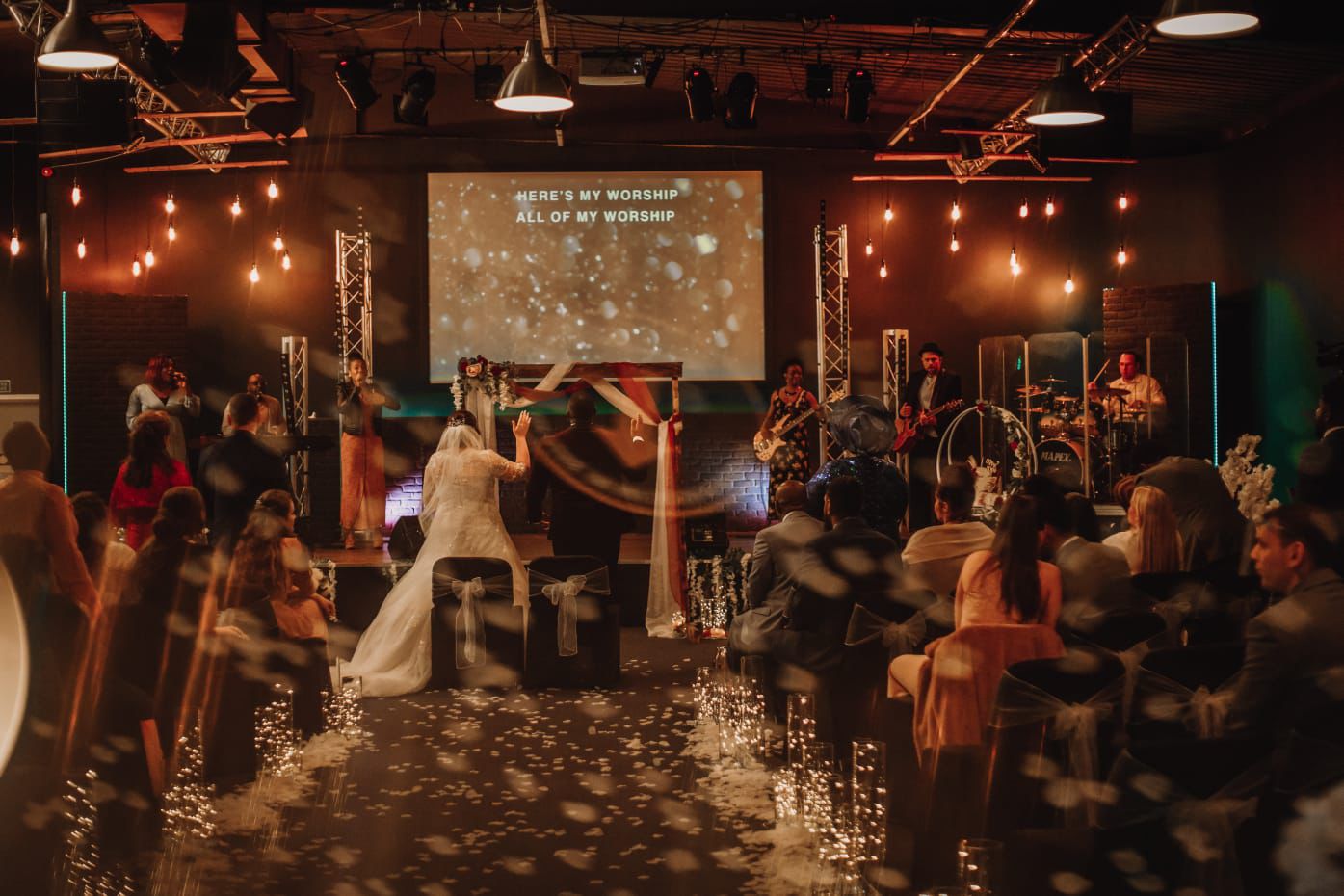 Wedding reception in elegant function hall with band and festive confetti.