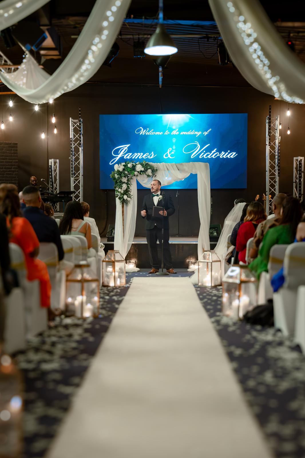 Elegant wedding ceremony in Large Function Hall, decorated arch and glowing lanterns.