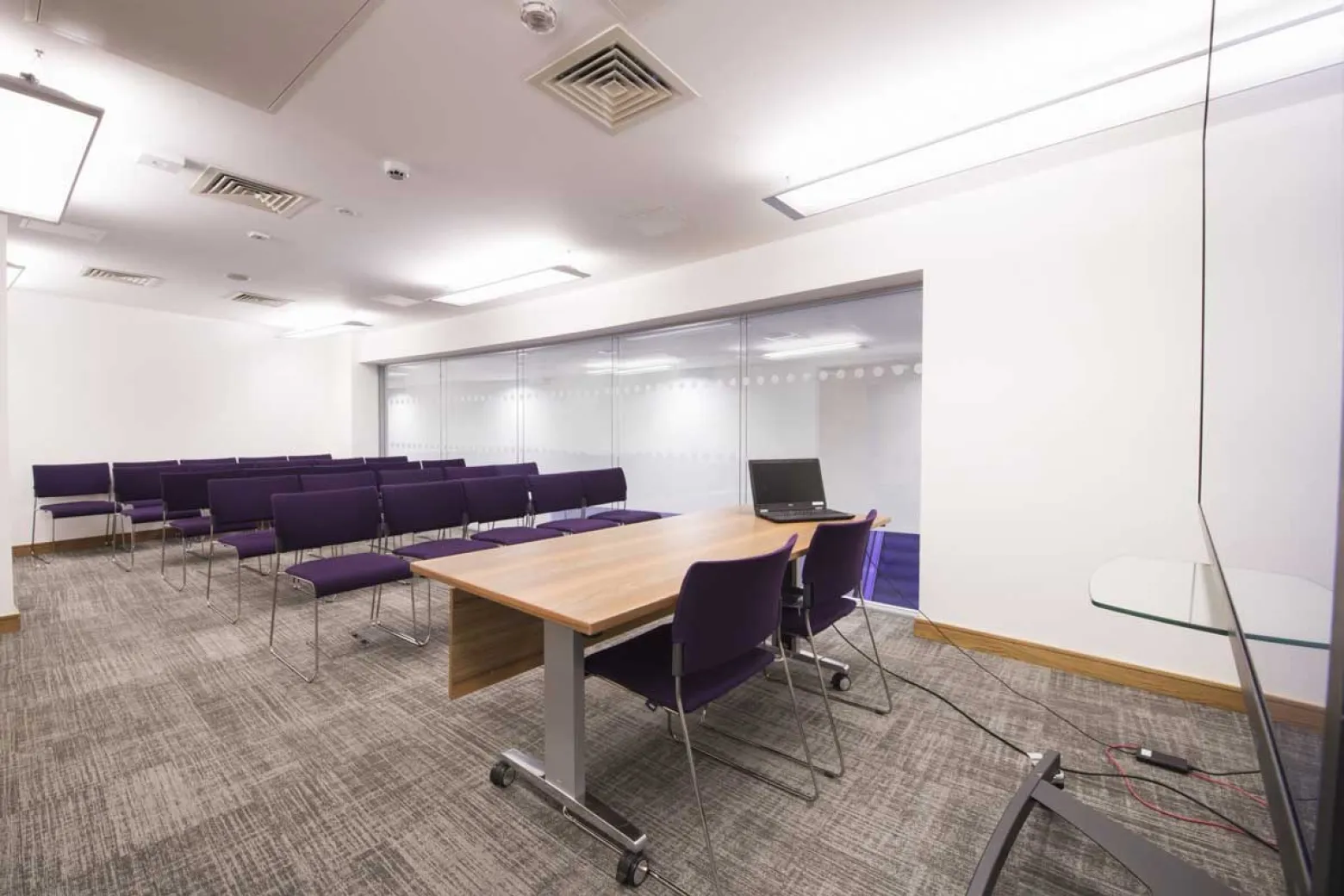 Modern Boardroom 2 at ICC Belfast with purple chairs for workshops and meetings.