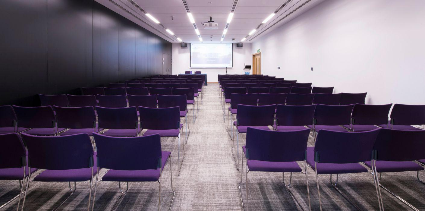 Main Auditorium at ICC Belfast with purple chairs, perfect for conferences and workshops.