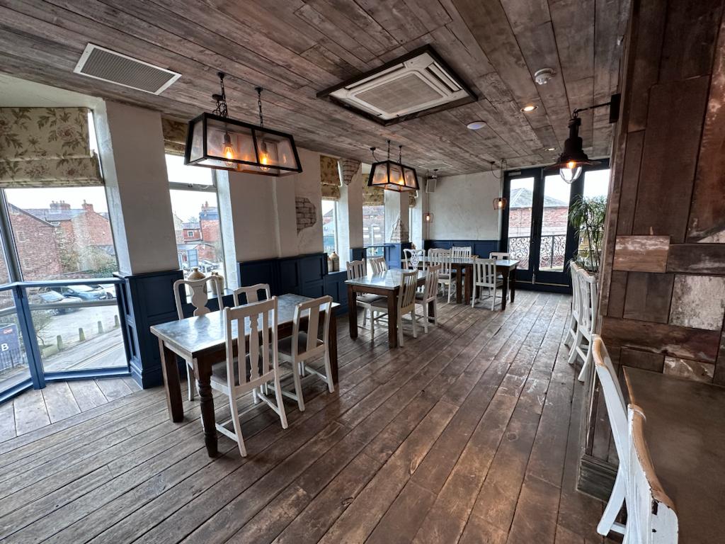 Spacious rustic venue with natural light for intimate gatherings and meetings.