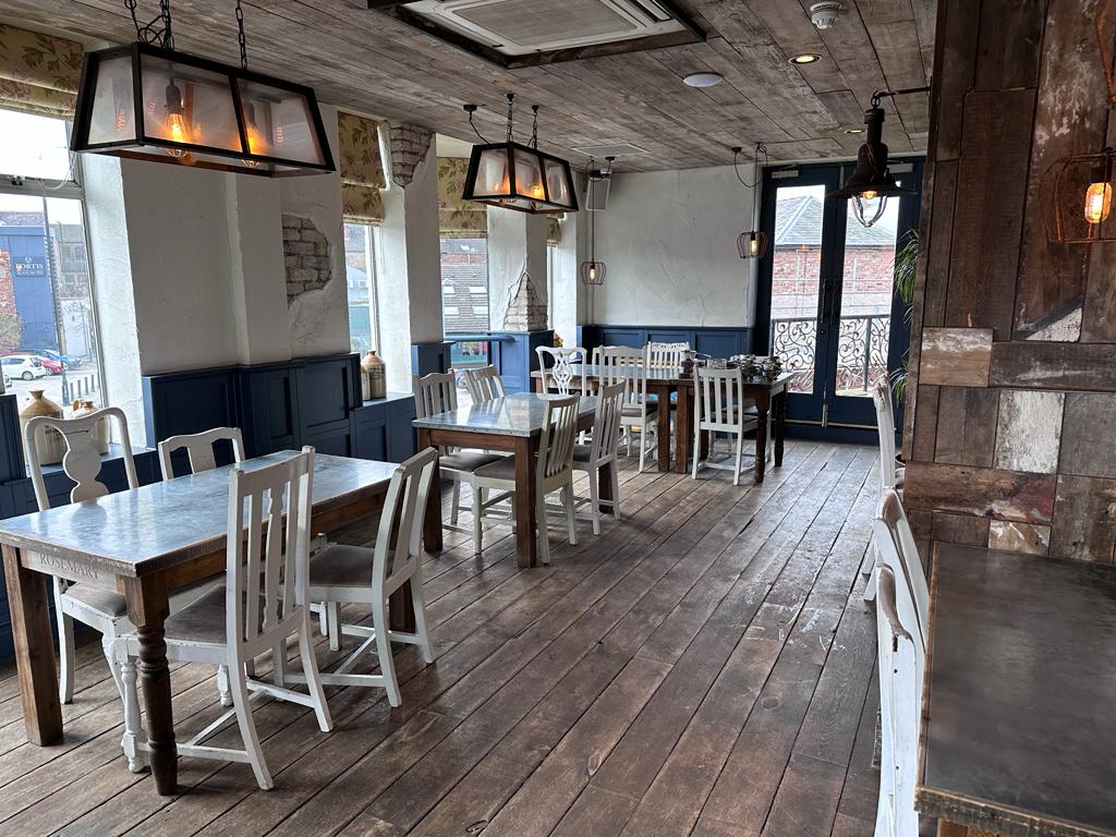 Charming rustic venue with wooden tables for intimate gatherings and meetings.