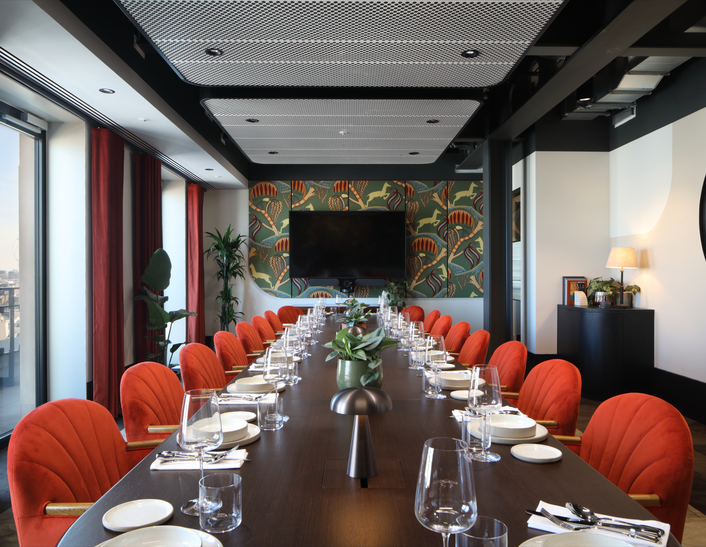 Stylish meeting room with wooden table and orange chairs, perfect for corporate events.