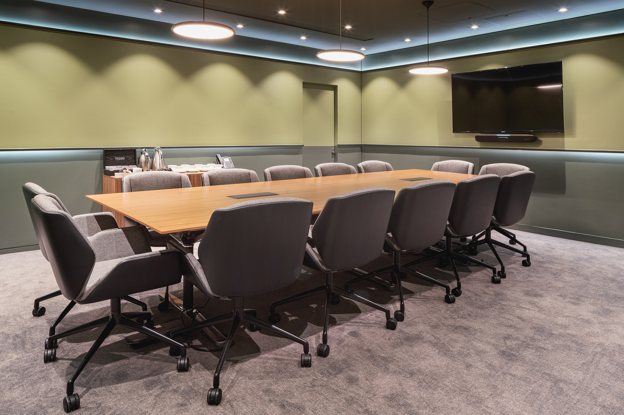 Modern conference room with wooden table, perfect for professional meetings and events.