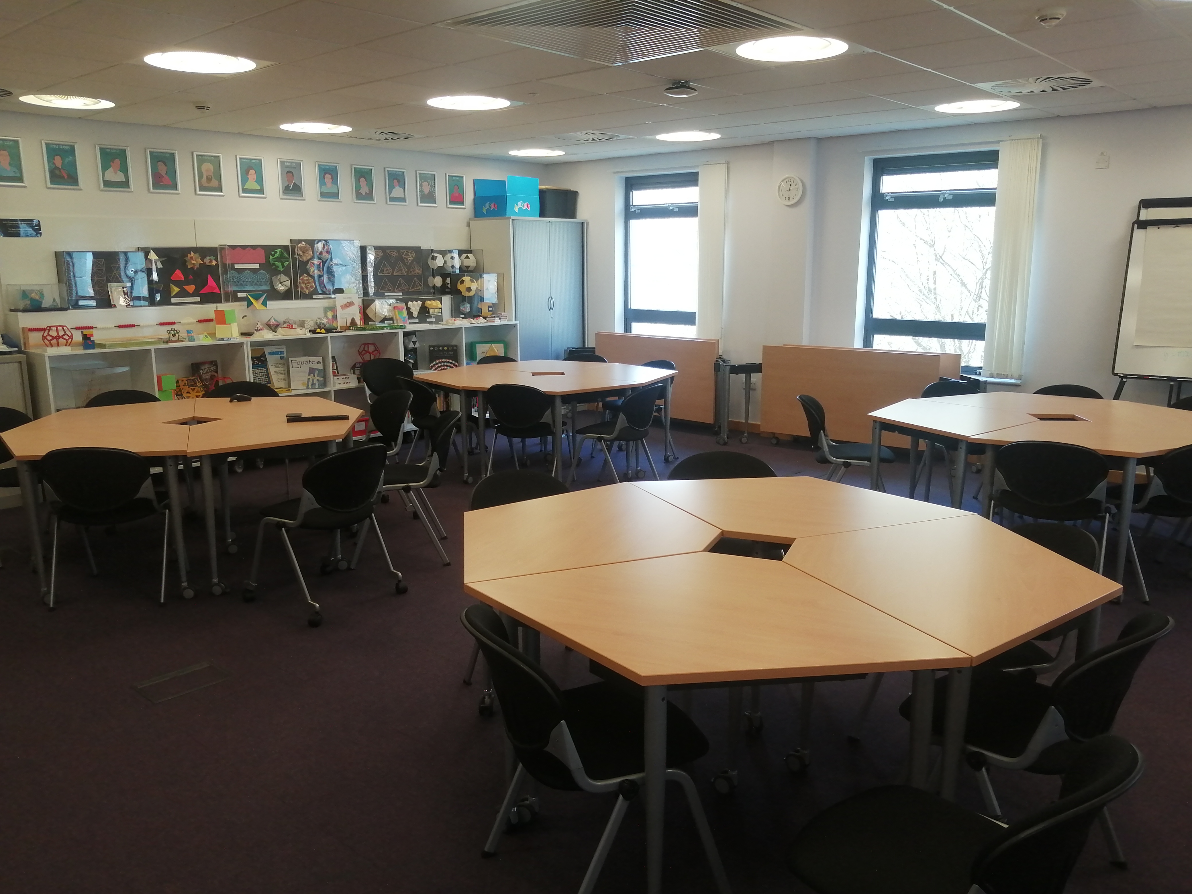 Versatile teaching room with hexagonal tables for STEM workshops and collaboration.