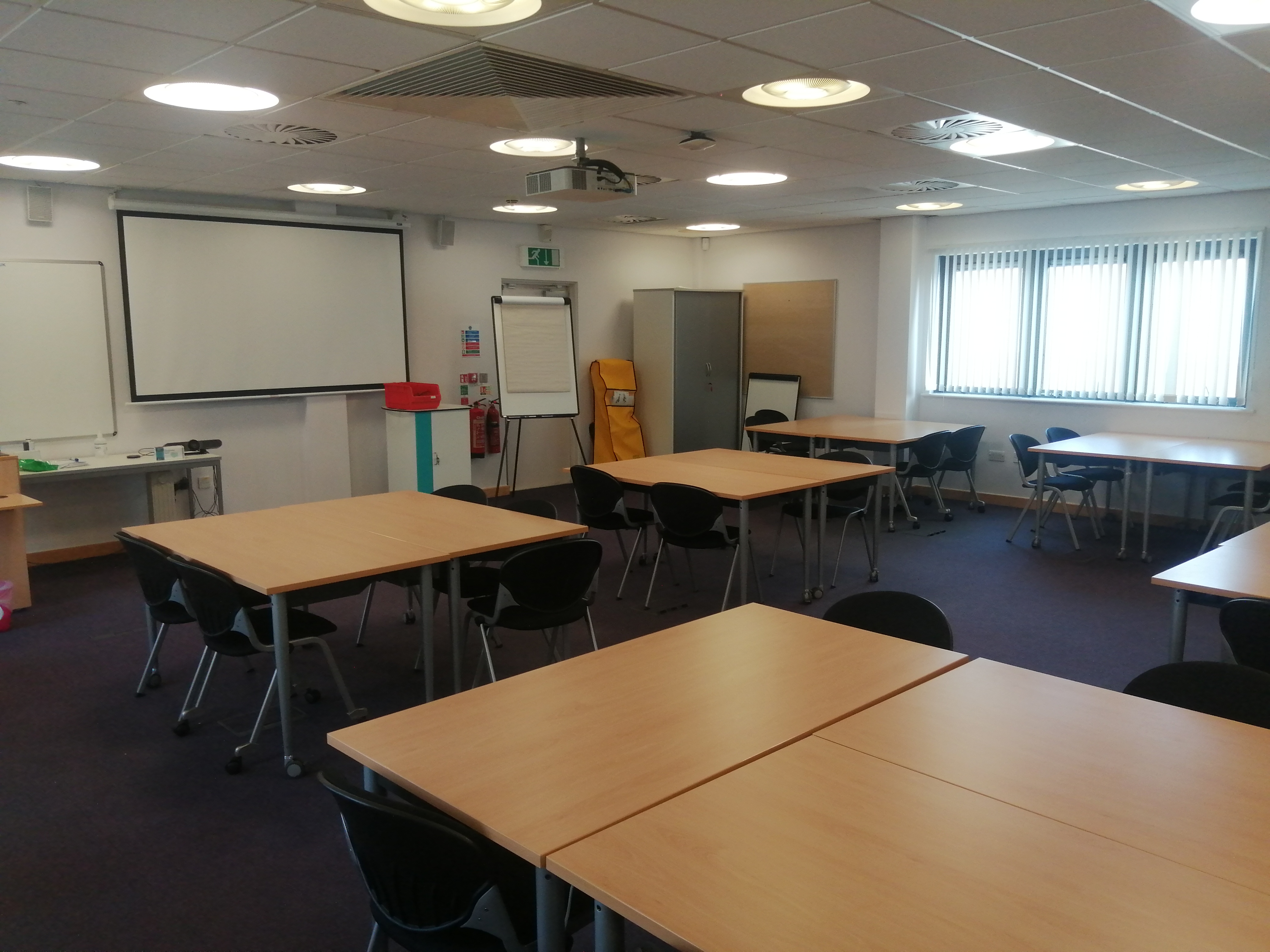 Versatile teaching room with modular tables for STEM workshops and presentations.