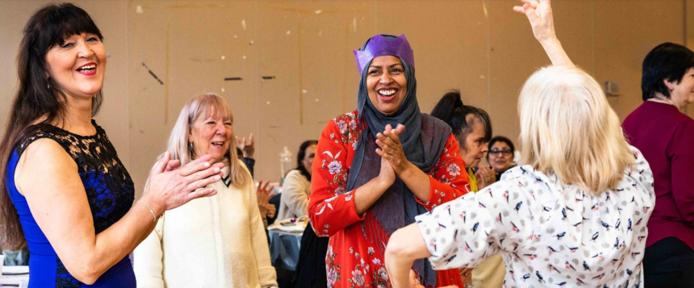 Middleton Hall event with diverse attendees enjoying interactive activities and party hats.