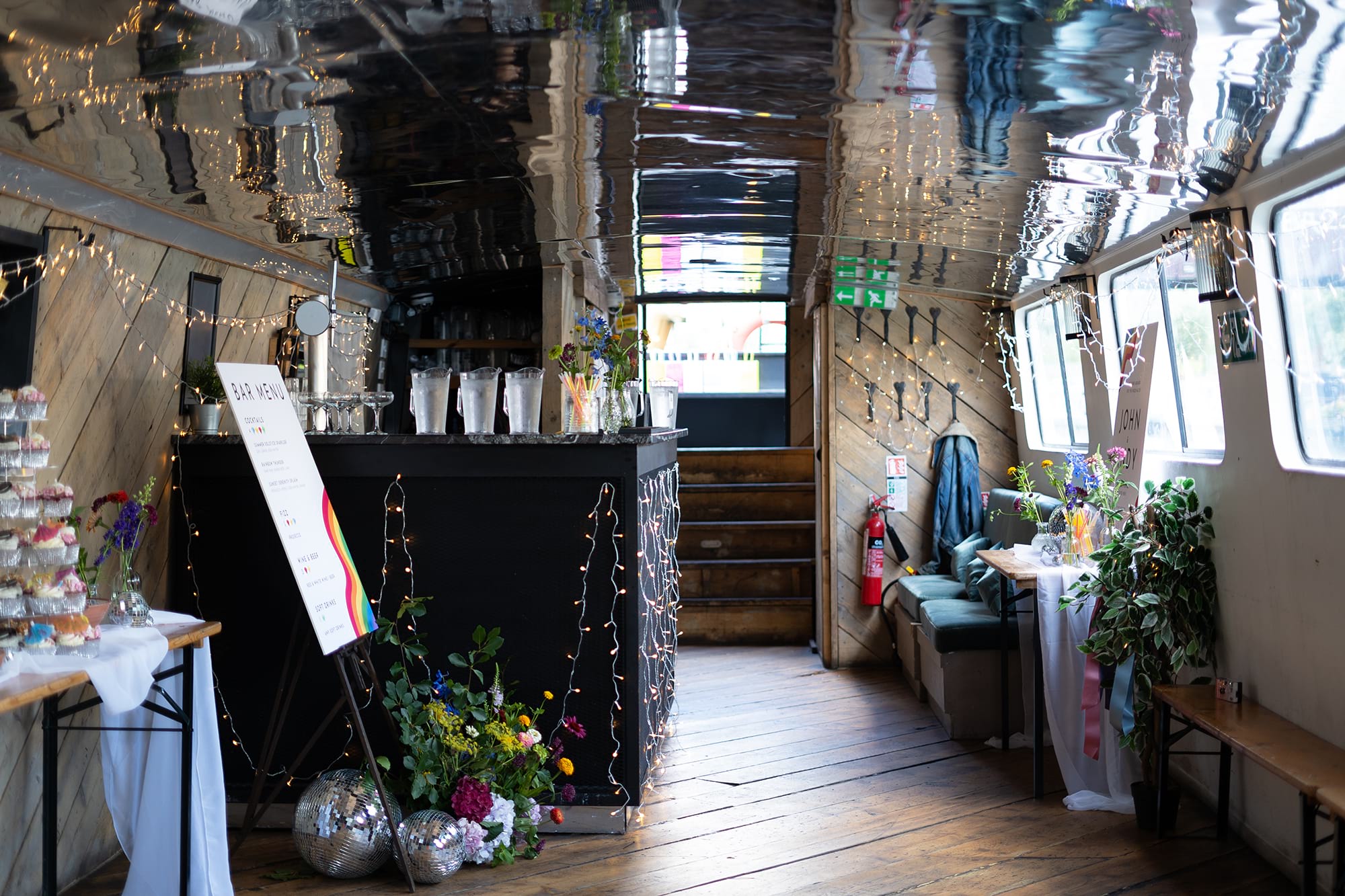 Event space on Mary Read Boat with wooden interior and ambient lighting in Hackney Wick.