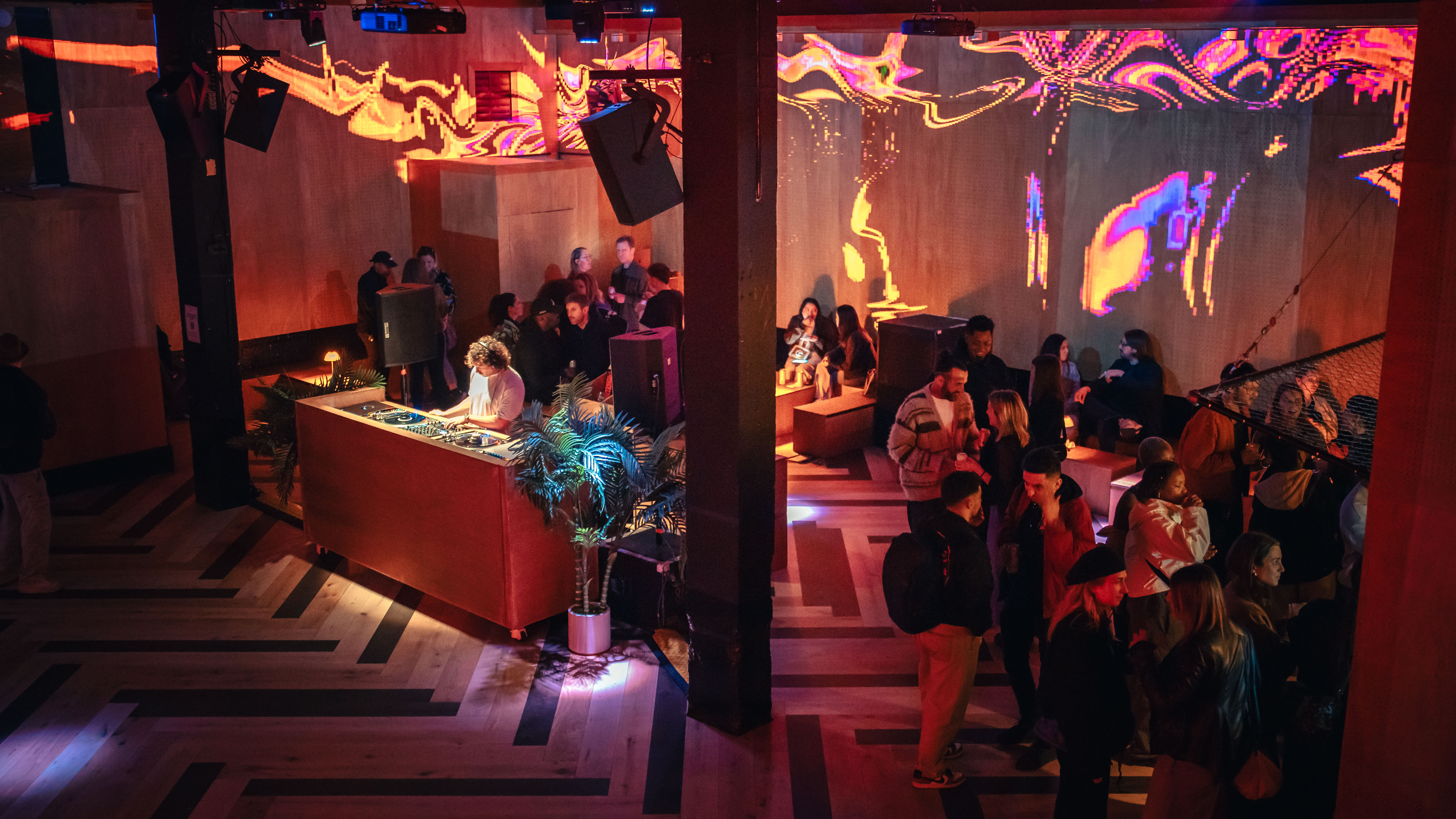 DJ at vibrant Christmas event in Hackney Wick with dynamic lighting and networking.