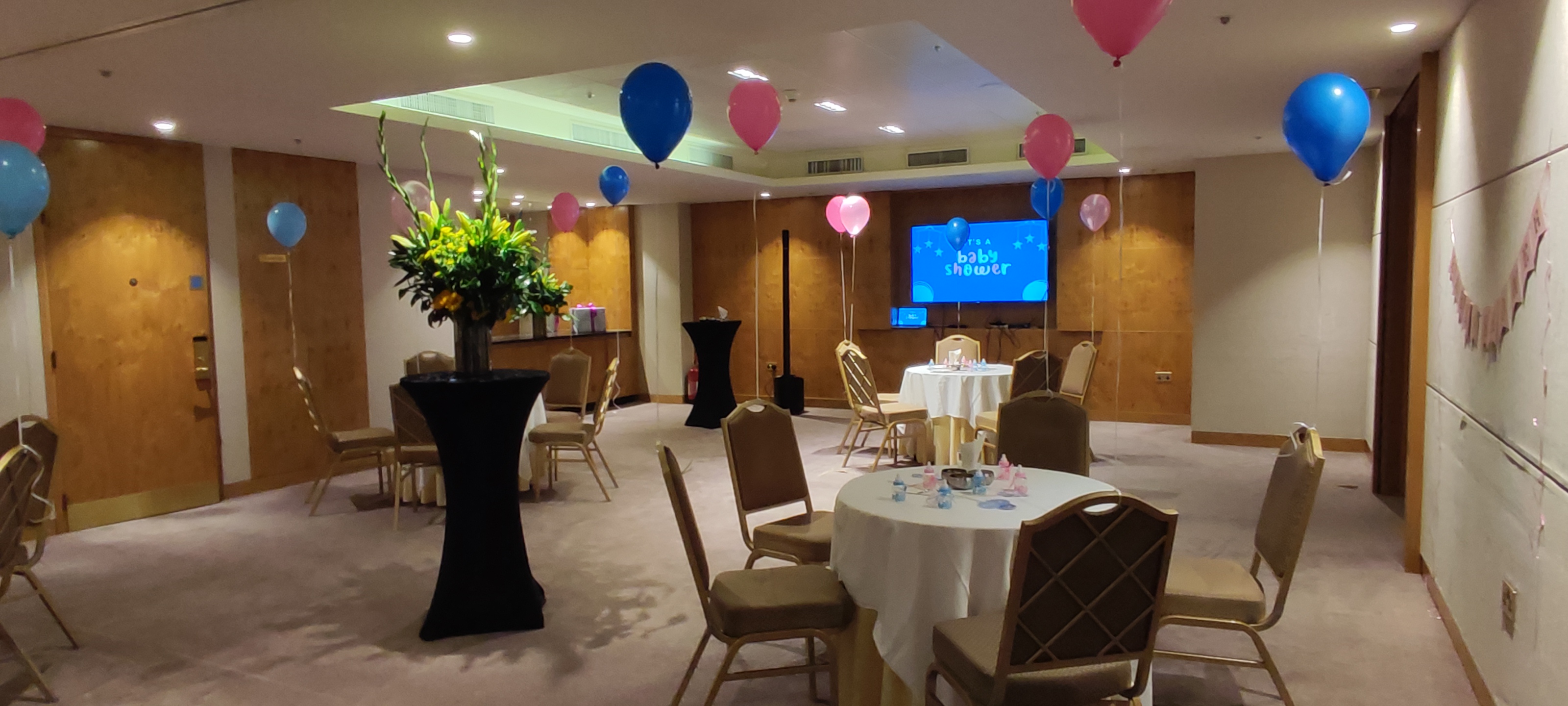Landmark Rooms event space with balloons and floral centerpiece for celebrations.