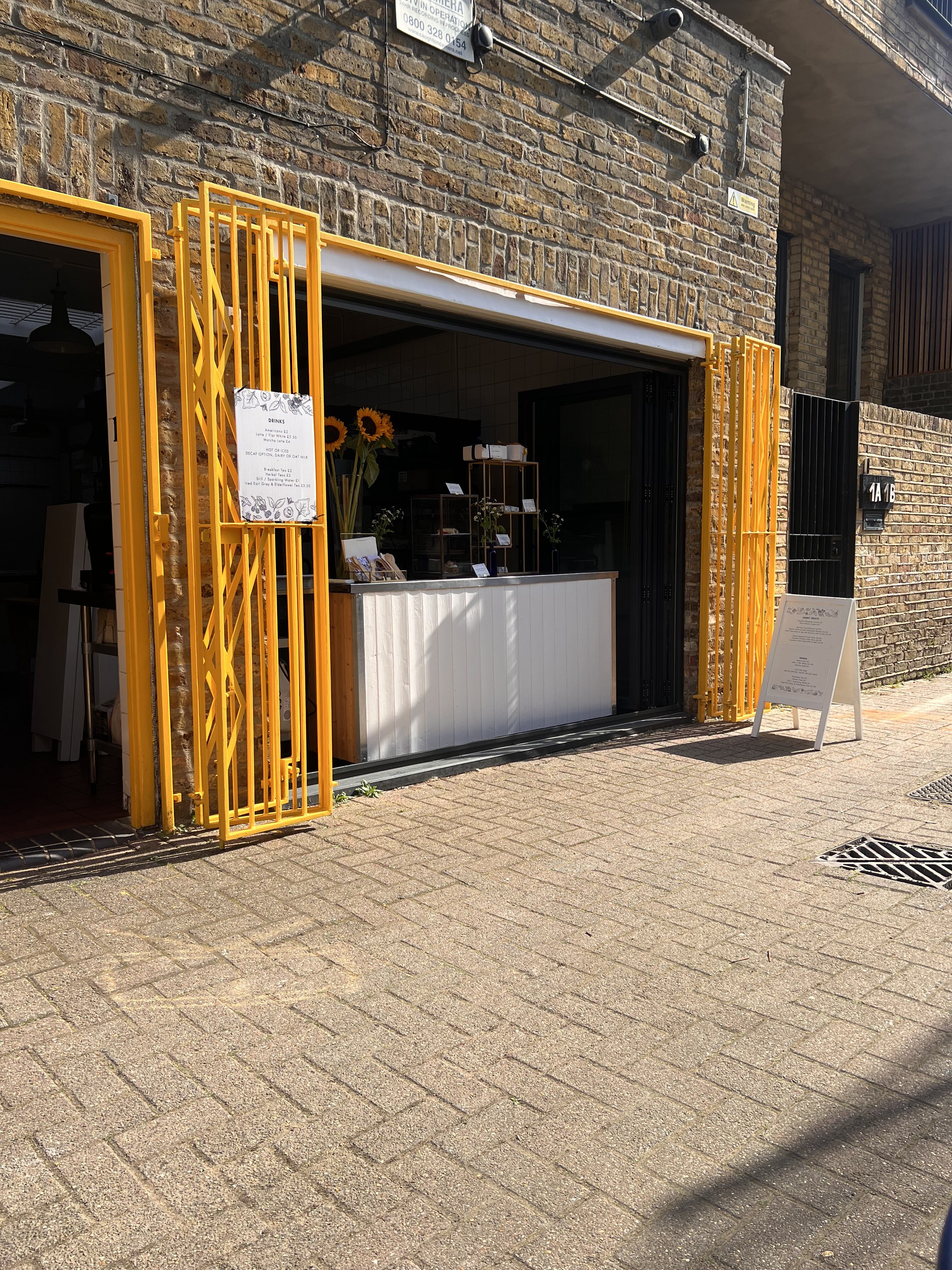Vibrant EK Bakery entrance with yellow gates, perfect for casual events and meetings.