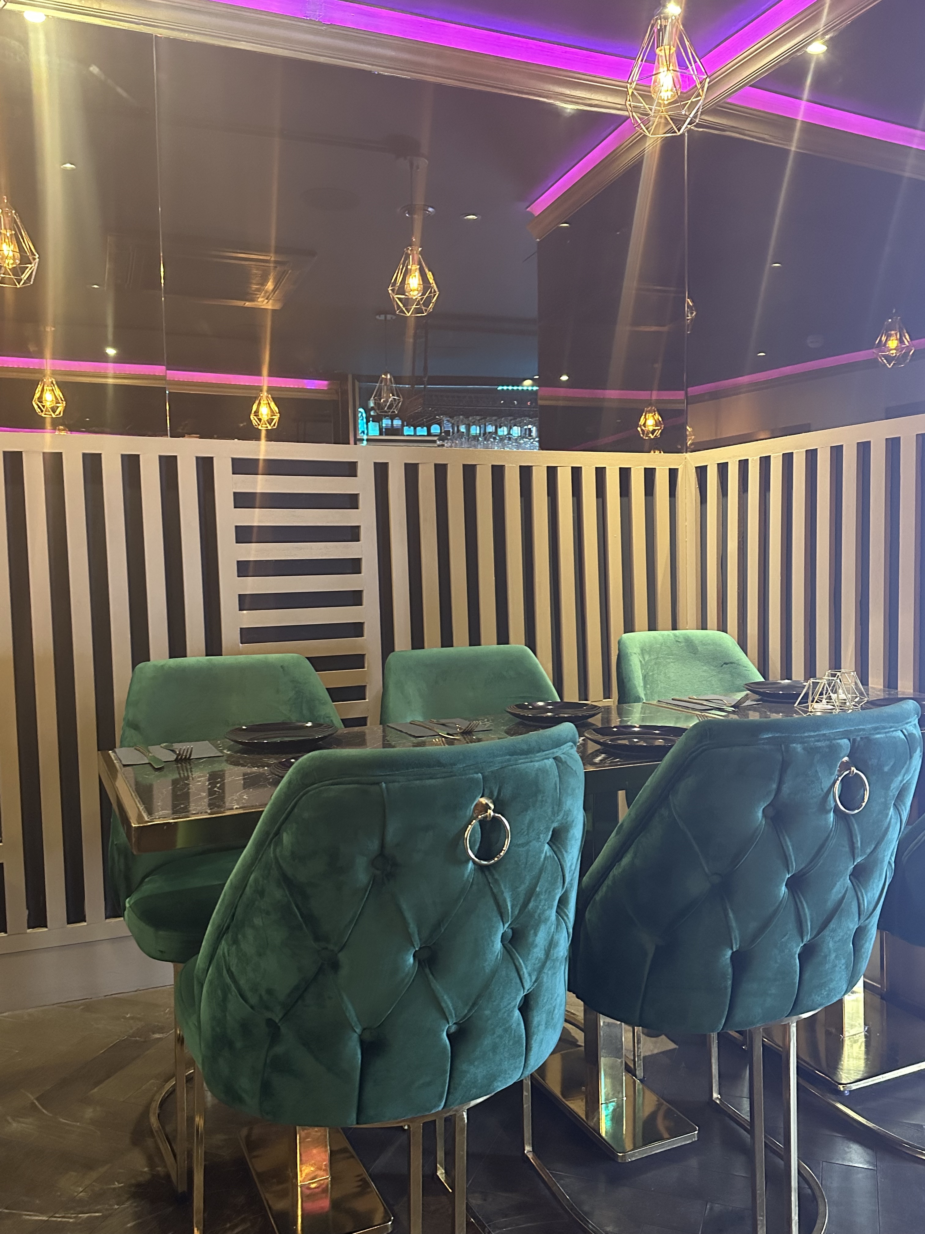 Chic Maharani Lounge dining setup with plush teal chairs for intimate events.