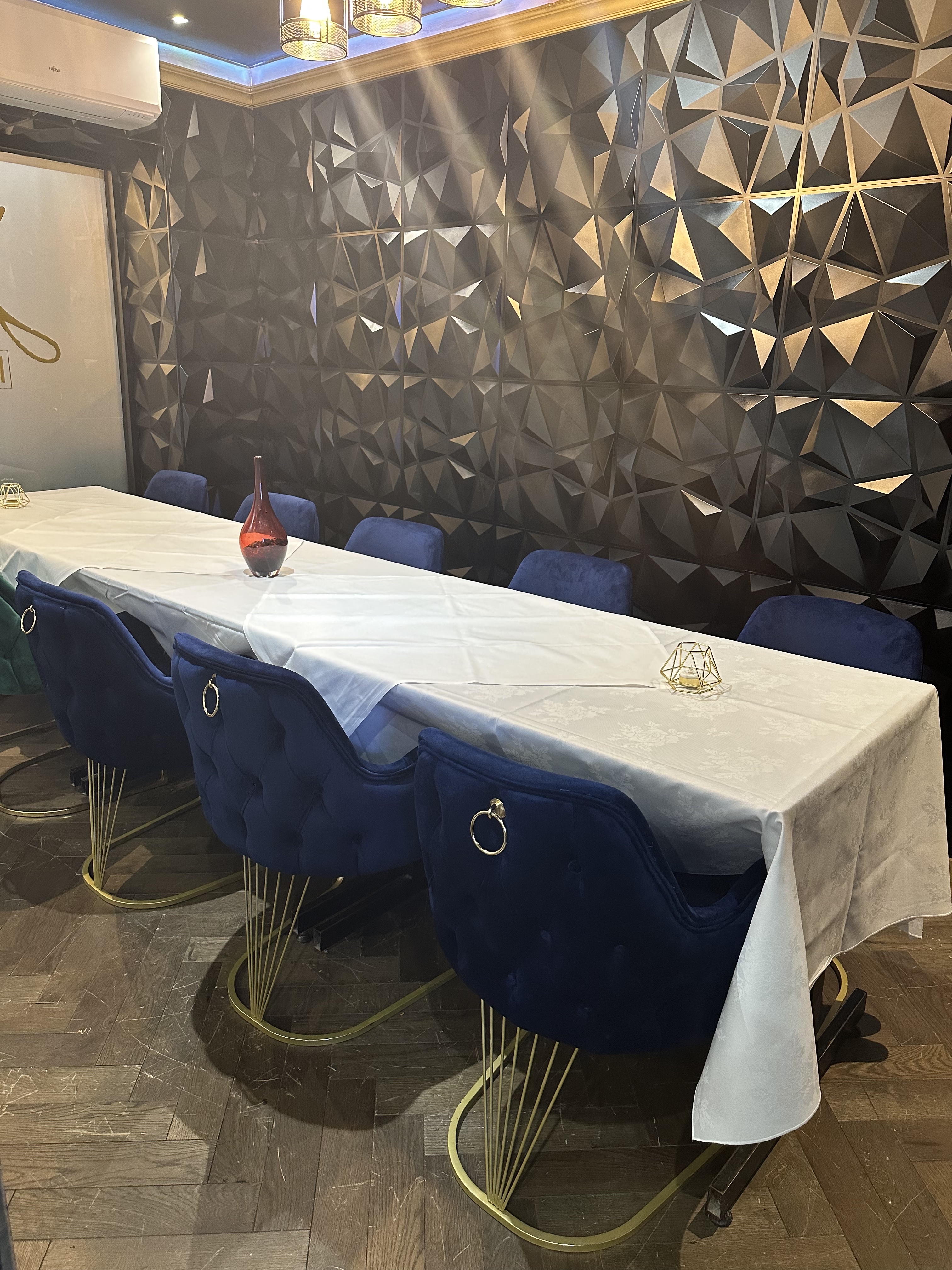 Modern meeting space with long table and plush blue chairs for upscale events.