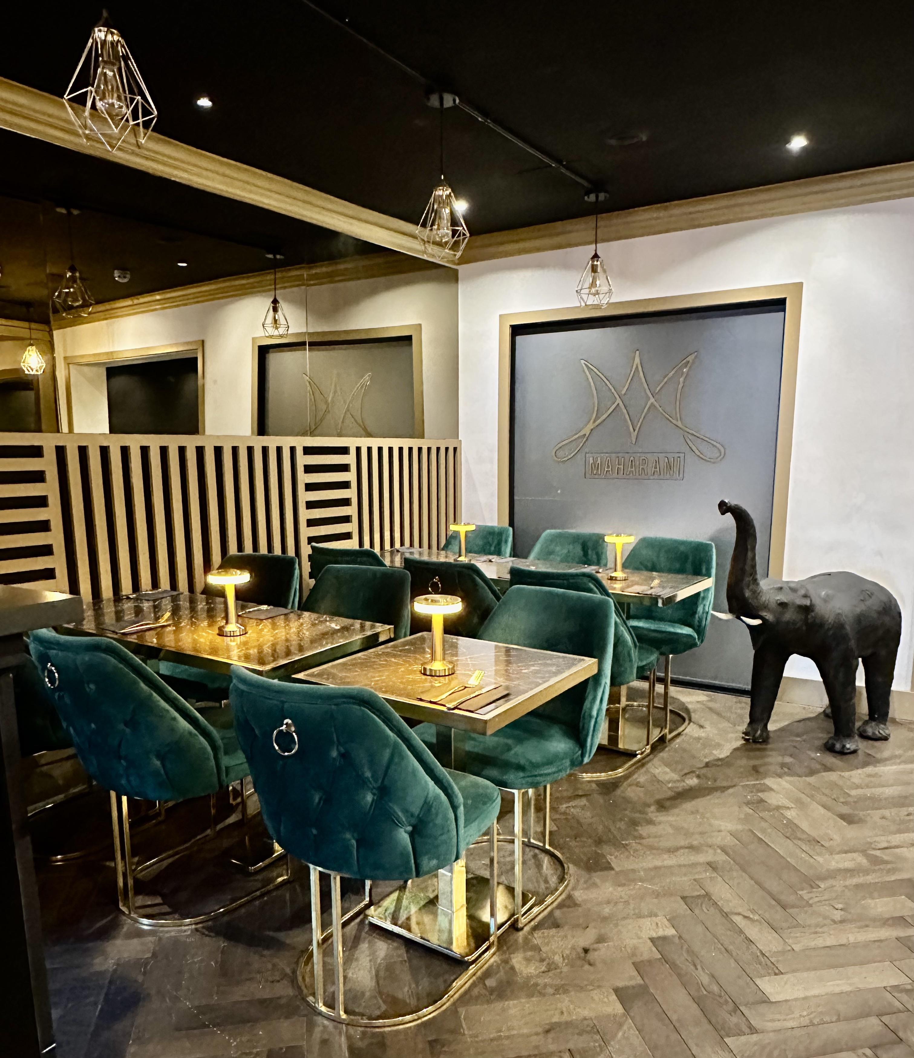 Stylish Maharani Lounge with plush green seating, perfect for meetings and gatherings.