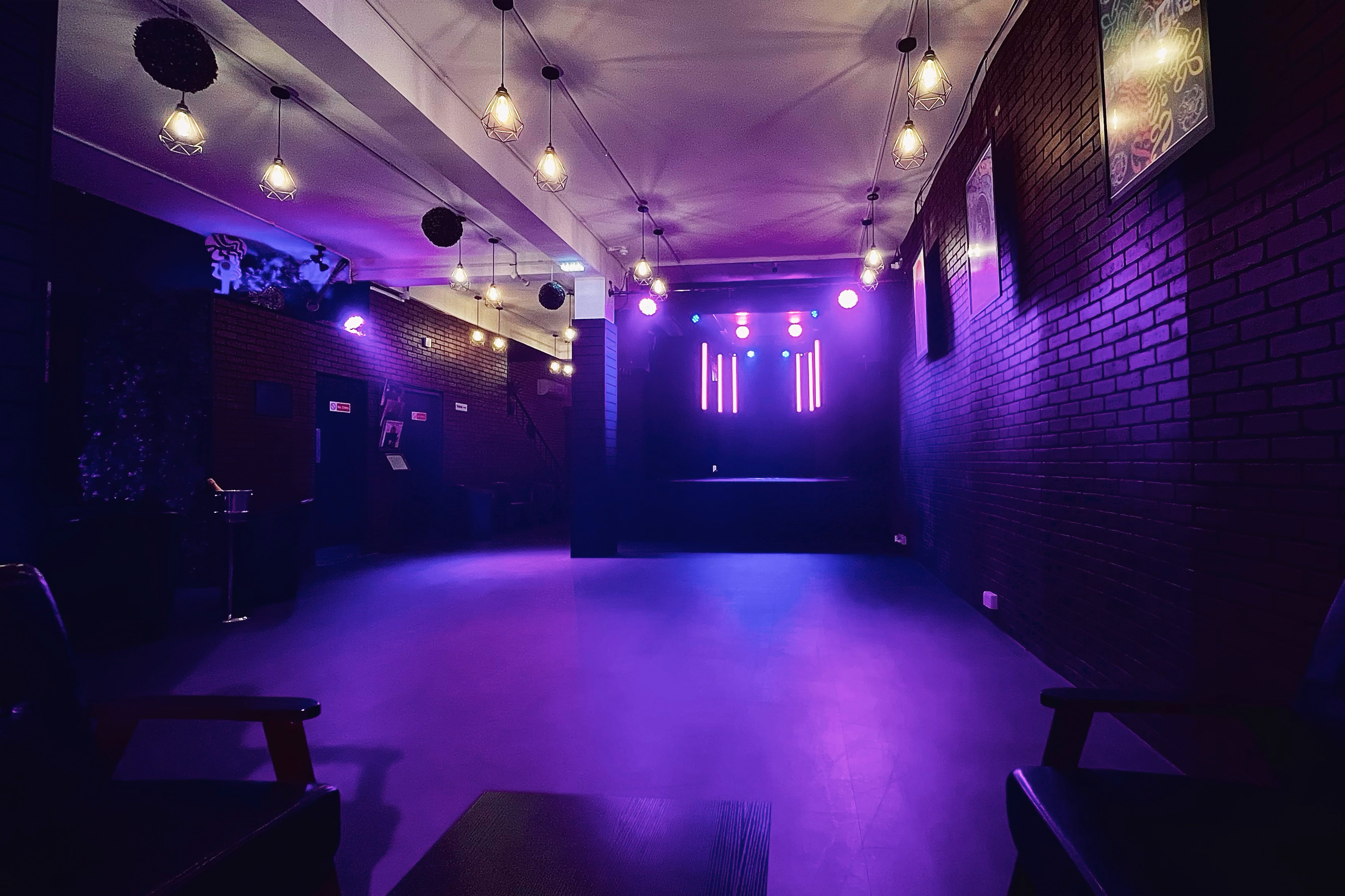Versatile event space at Fusion Creative Studios with vibrant purple stage lighting.