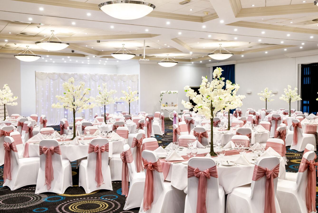 Telford Suite at Mercure Hotel, elegant wedding venue with pink sashes and floral decor.