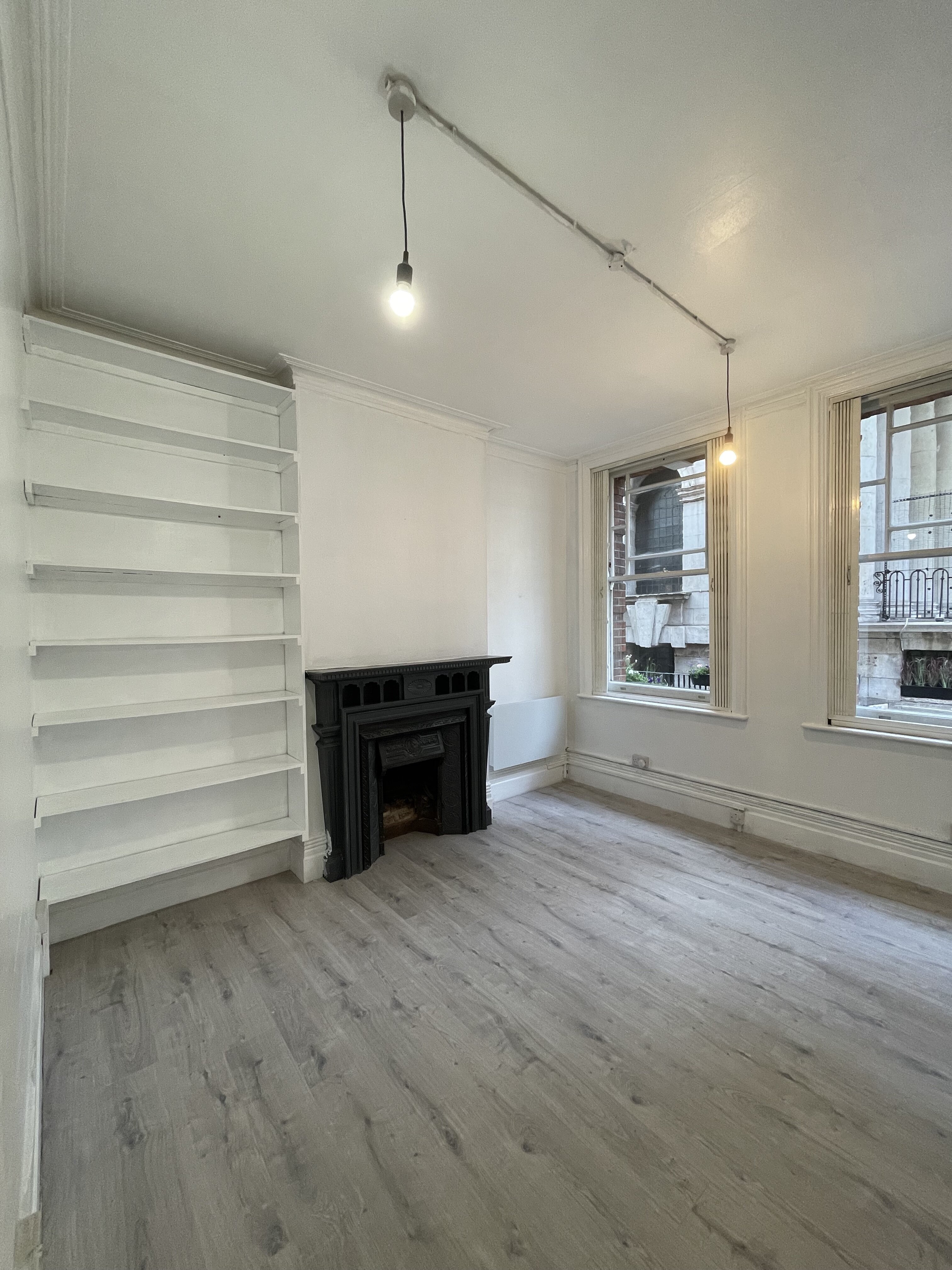 Minimalist meeting space with natural light and fireplace for workshops or intimate gatherings.