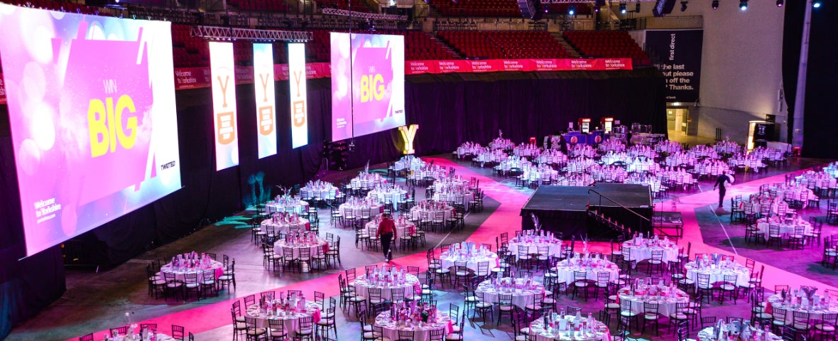 "First Direct Arena Leeds auditorium setup for conferences and gala dinners with vibrant lighting."