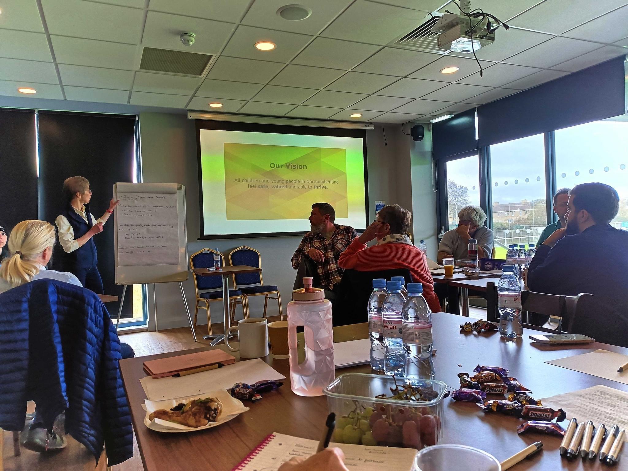 Professional meeting at Ashington Football Club with speaker and projector for training.