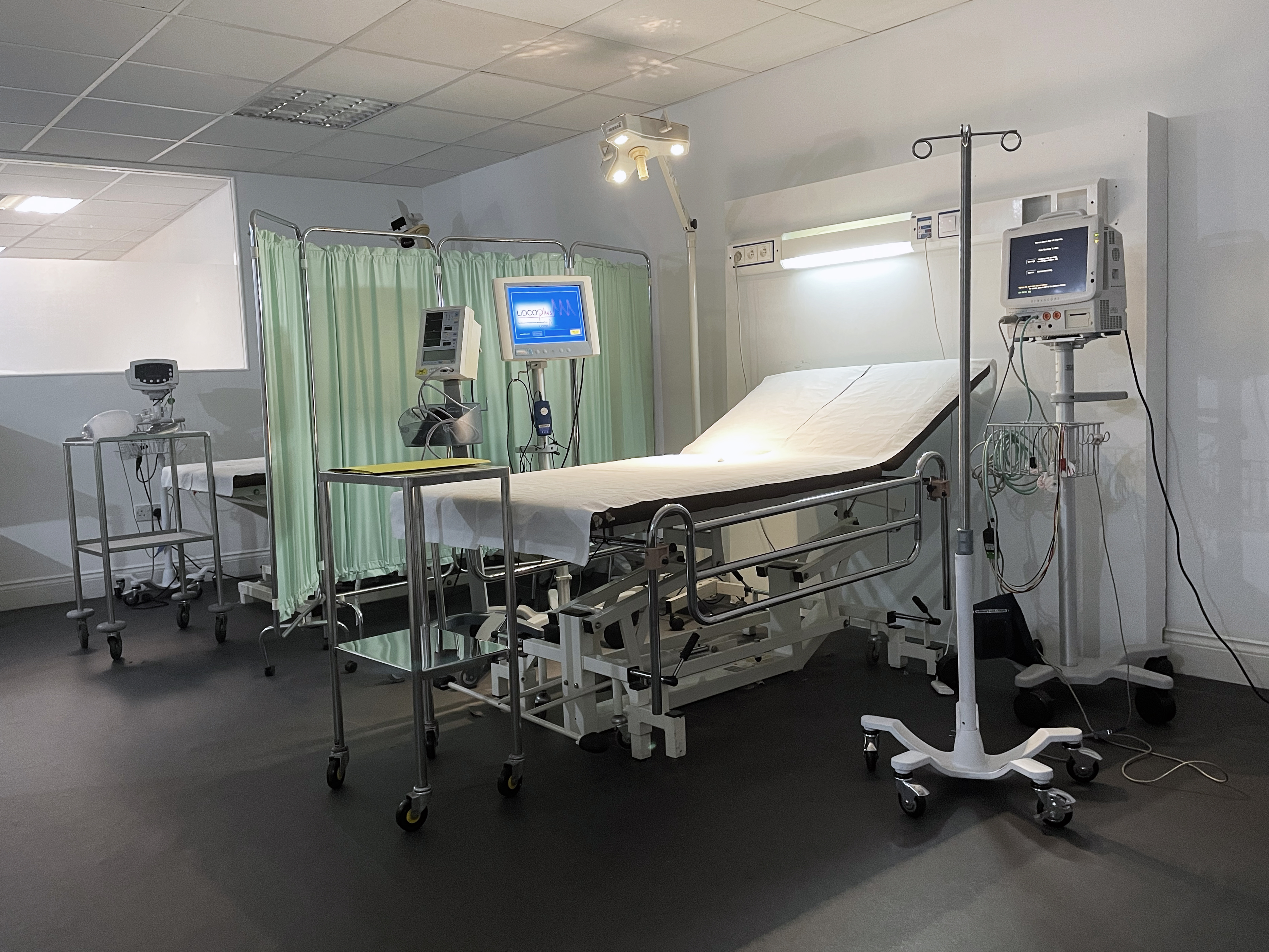 Hospital room with bed and medical equipment for health conferences and workshops.