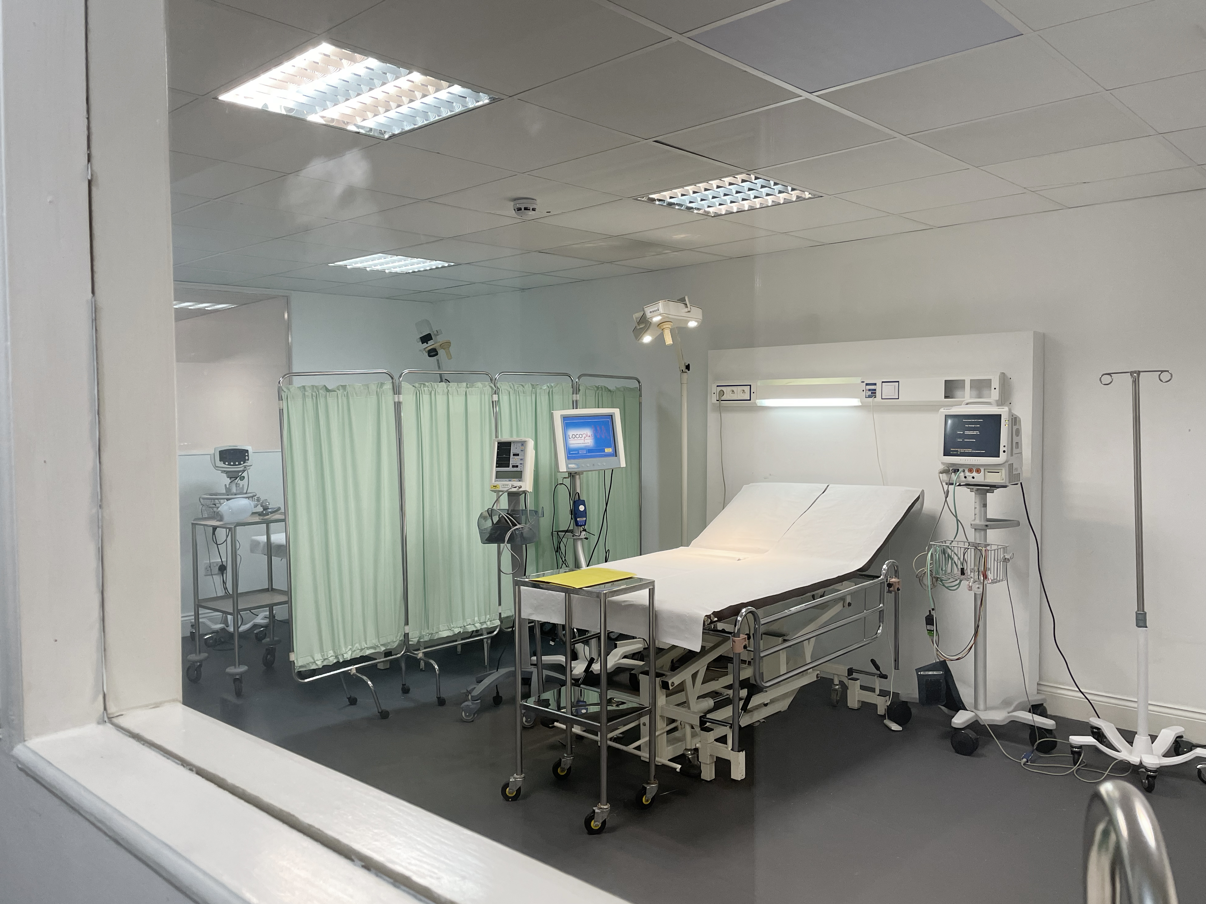 Sterile hospital room with bed and equipment for health conferences and workshops.