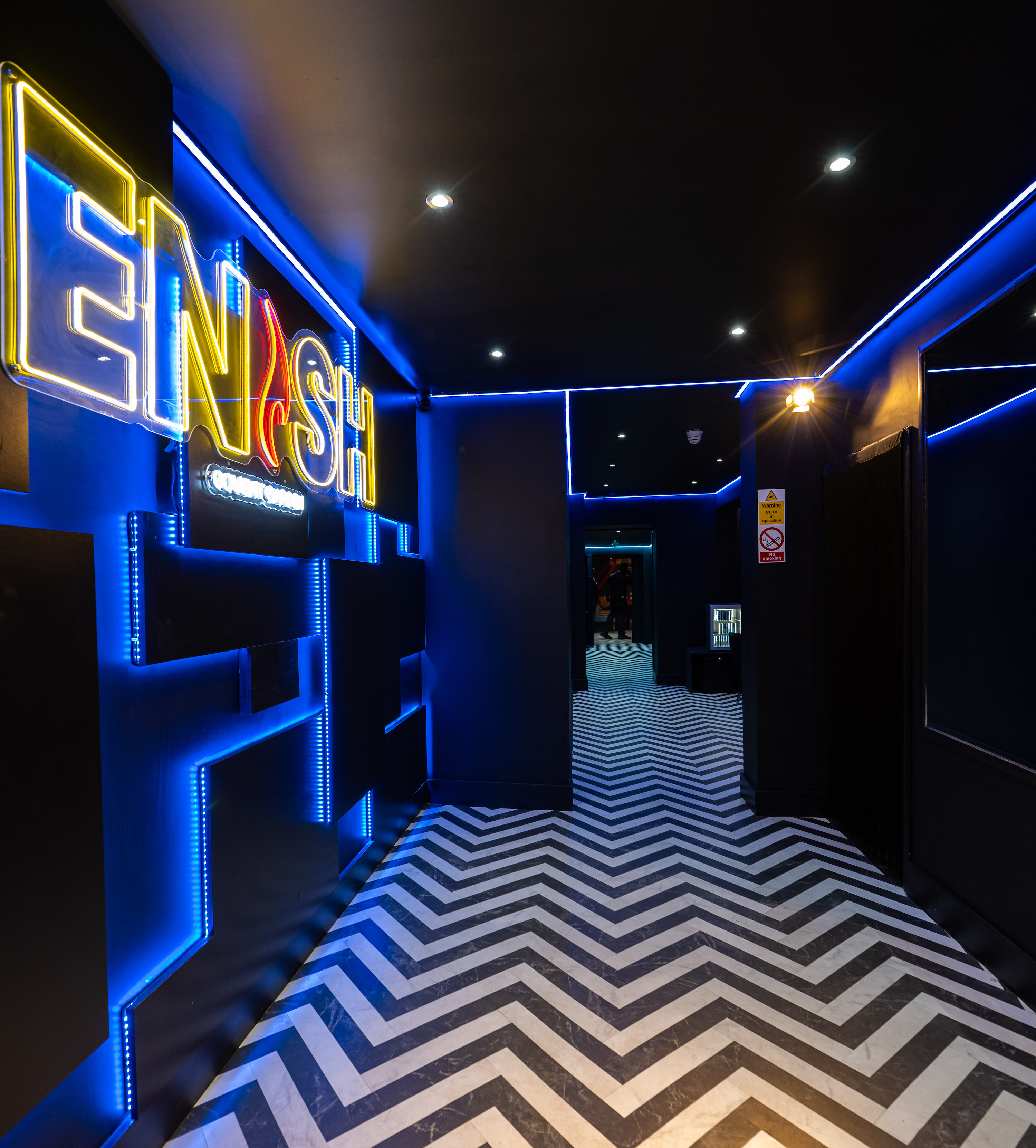 Modern lounge corridor with blue lighting, ideal for events and social gatherings.