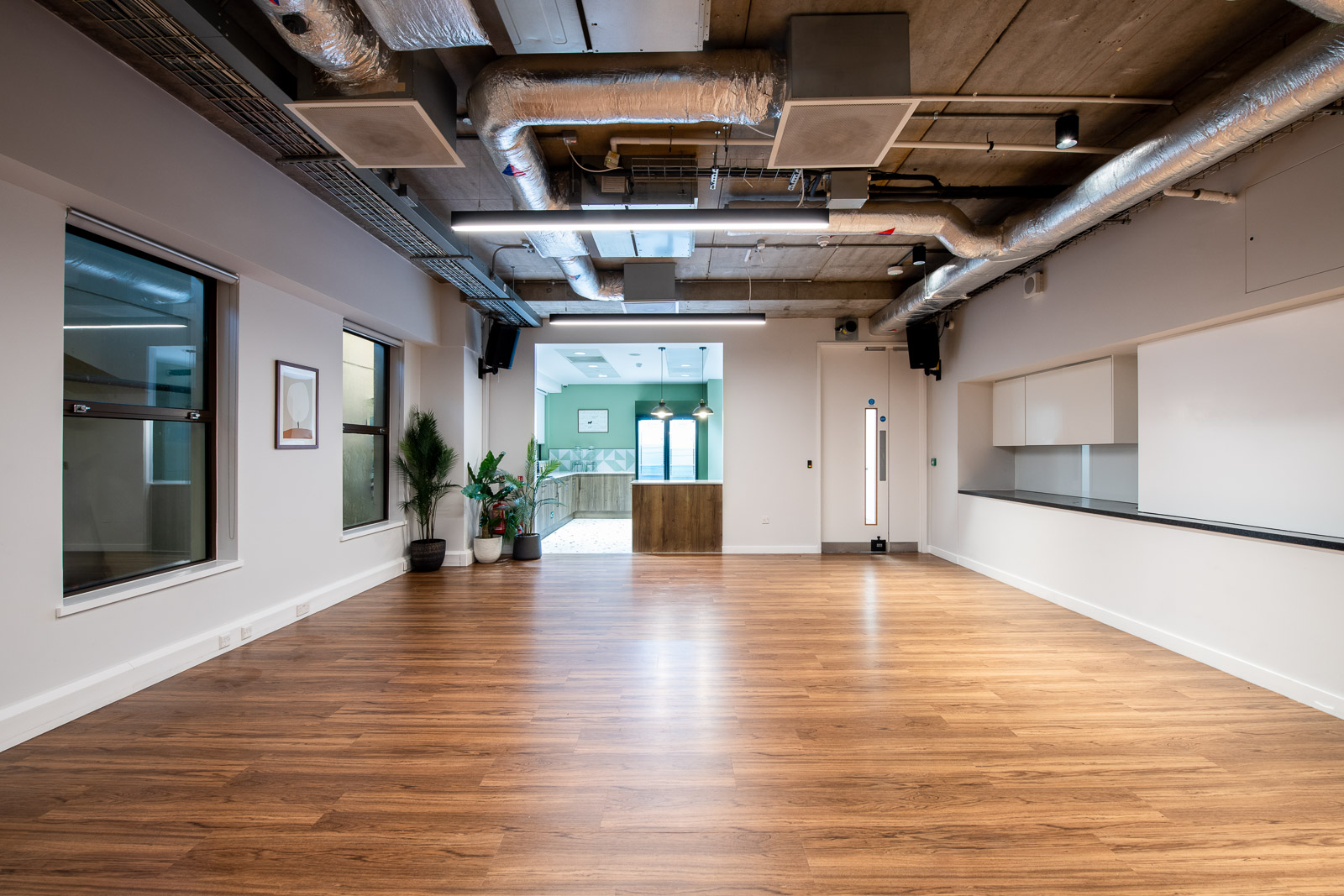 Versatile BL Event Space with polished wood floors, ideal for meetings and workshops.