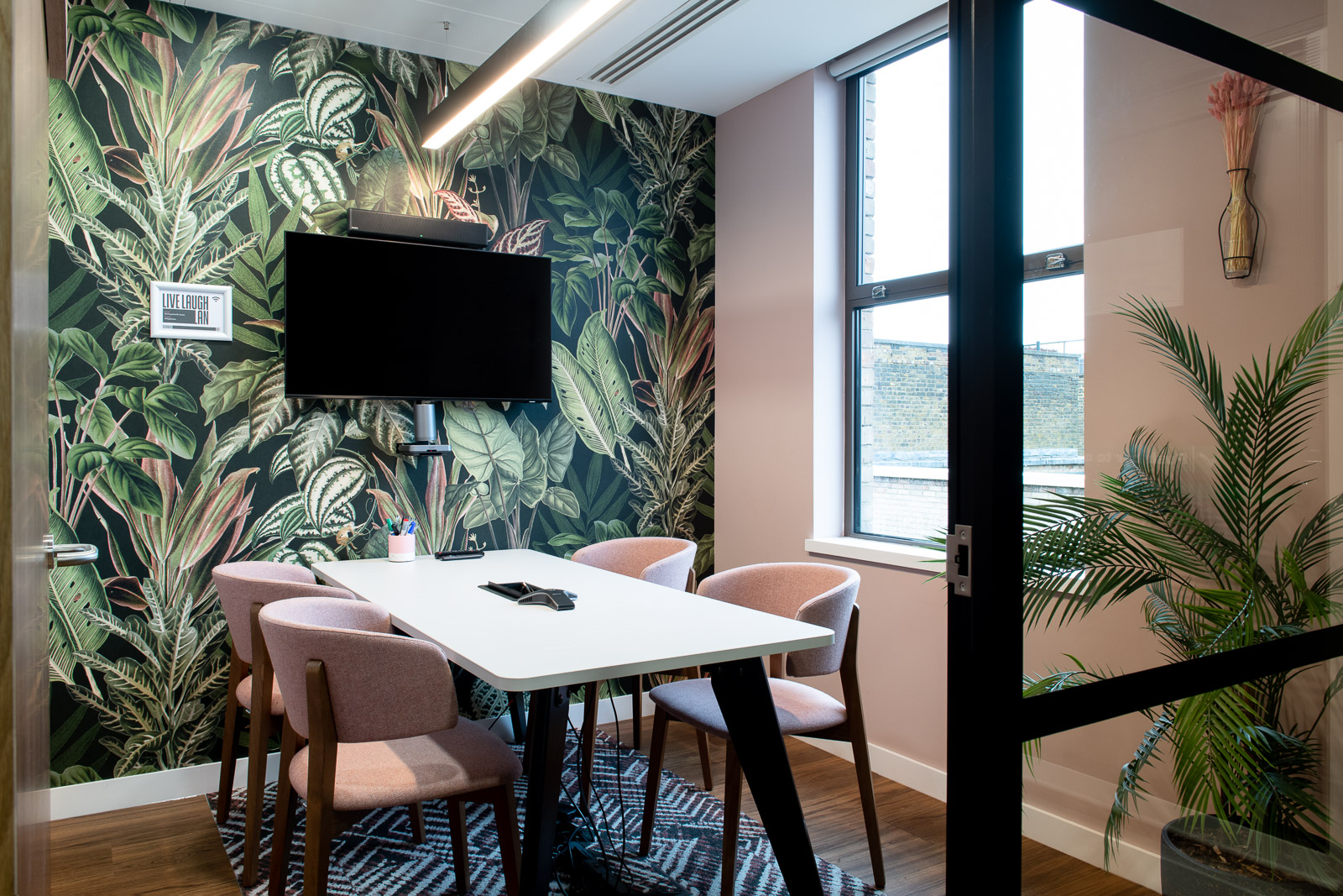 Modern meeting room with tropical wallpaper at Runway East Bloomsbury for collaborative events.